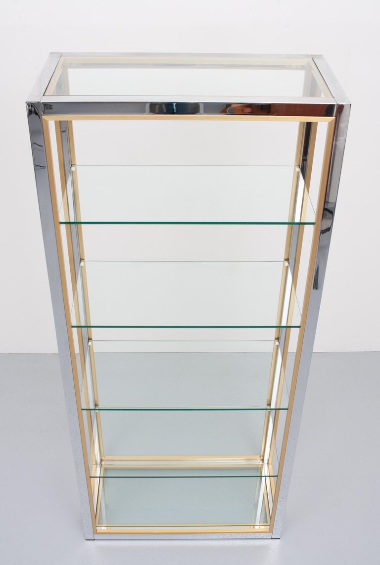 Love this display cabinet. Design by Renato Zevi, Italy, 1970s Chrome base with contrasting brass
lining. Comes complete with the 6 original cut glass shelves. Hollywood Regency style. Very good condition.