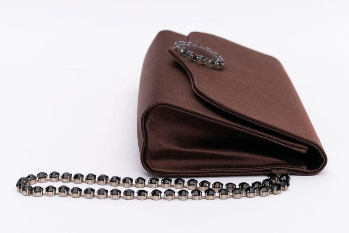 Renaud Pellegrino (Made in France) Clutch composed of brown satin embellished with rhinestones. Black satin lining.

Additional information: 
Dimensions: Width: 24 cm (9.44