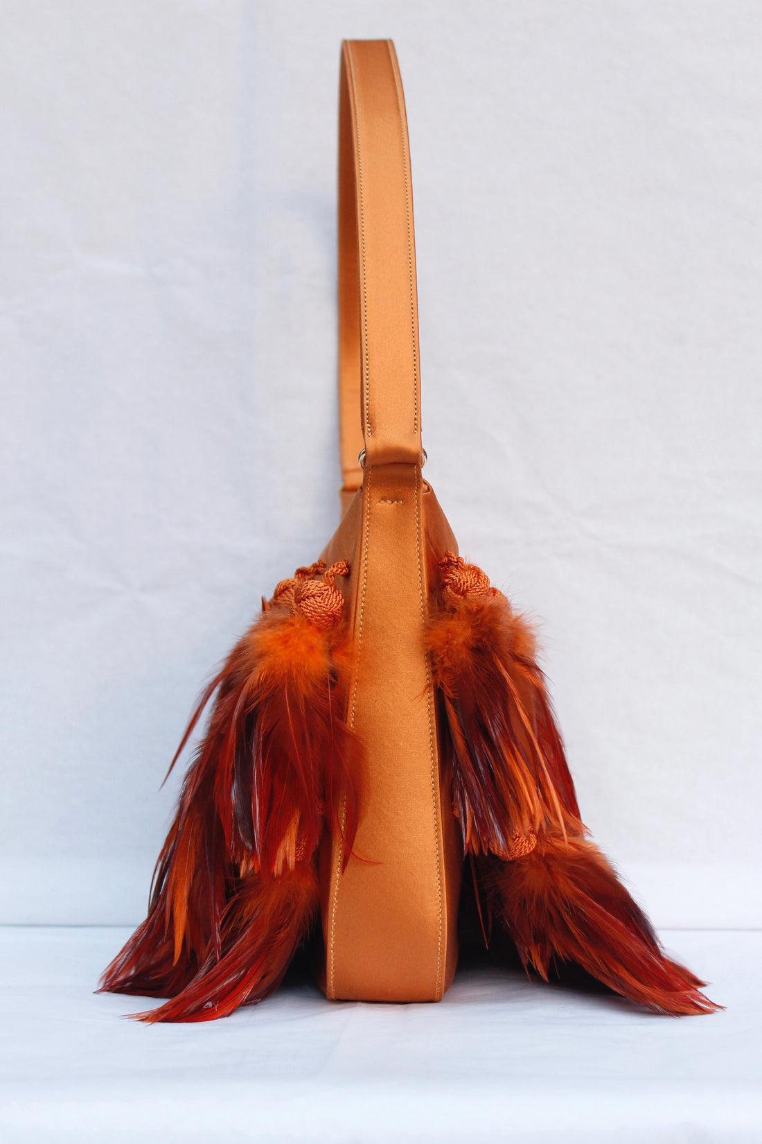 Renaud Pellegrino (Made in France) Orange satin bag with feathers, lined with orange satin.

Additional information: 
Dimensions: Height: 21 cm (8.26 in), Width: 22 cm (8.66 in), Depth: 4 cm (1.53 in), Handle: 50 cm (19.68 in)
Condition: Very good