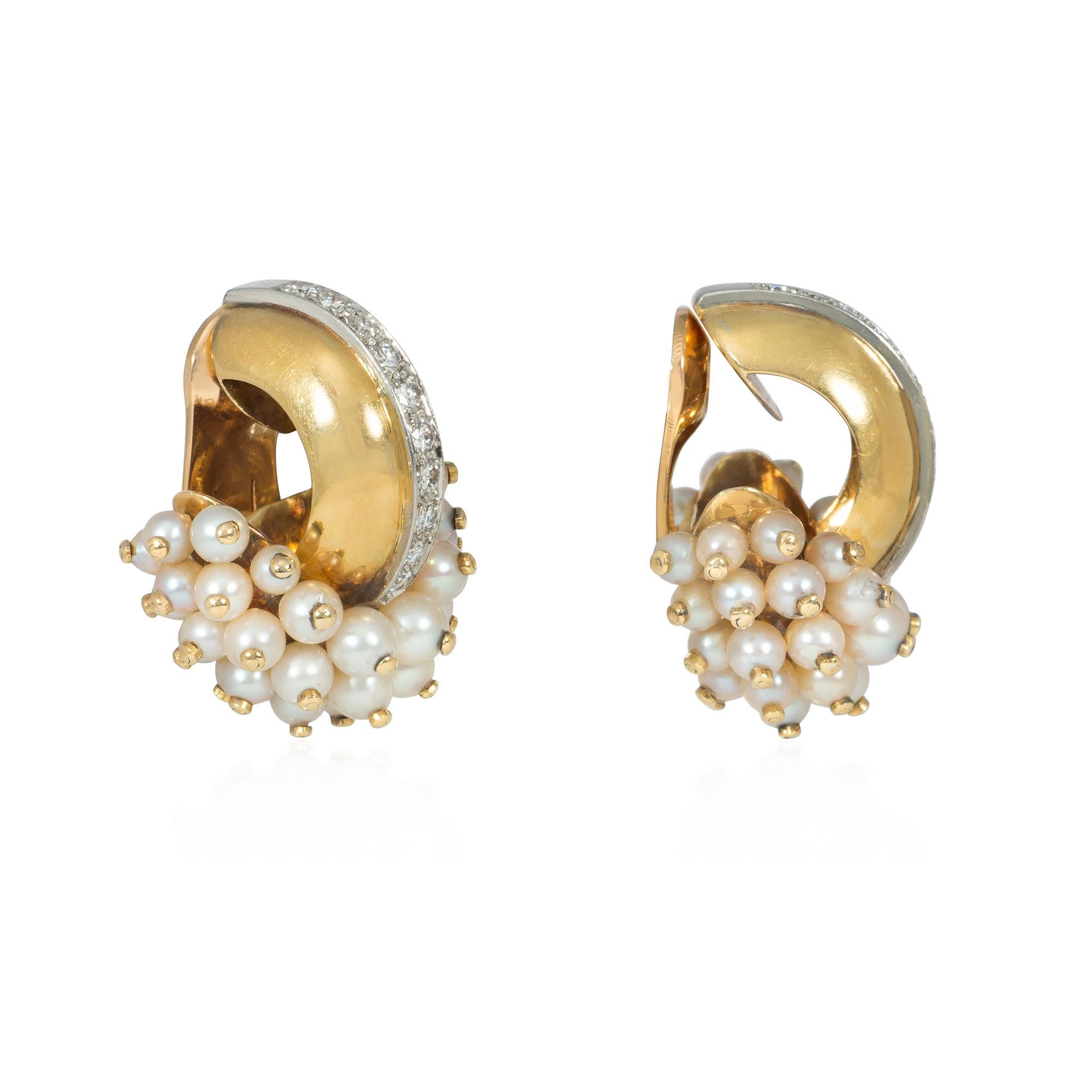A pair of Art Moderne earrings in the form of stylized doorknockers with gold-beaded pearl terminals arranged in overlapping rows, suspended from front-facing half-hoop gold surmounts bisected by a line of diamonds, in 18k with clip backs. René