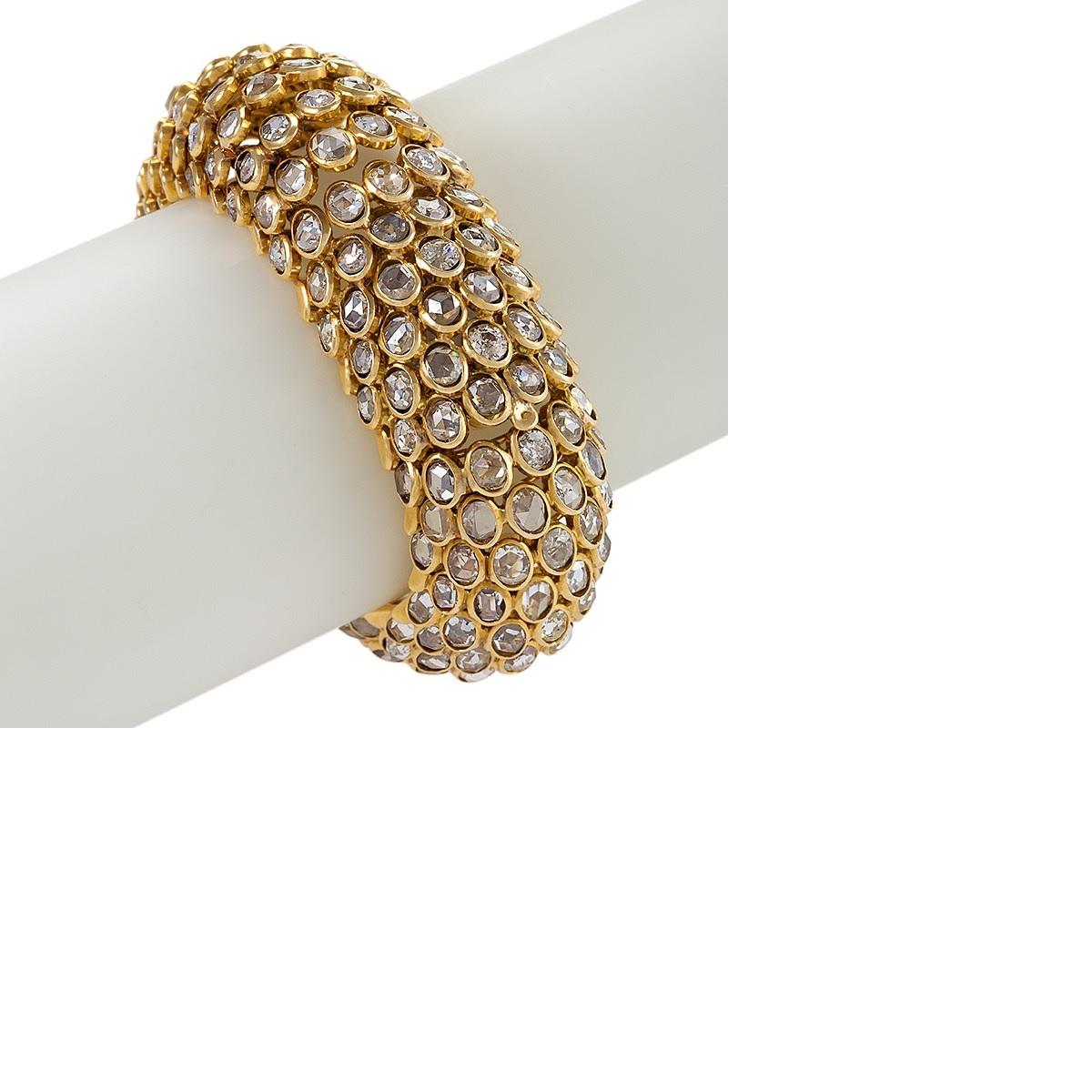 An 18 karat gold bracelet watch by René Boivin. The watch has 252 rose-cut diamonds that have the approximate total weight of  42.25 carats. The bracelet is executed in Boivin's famed fish-scale design, with angled tiers of oval-shaped rose-cut
