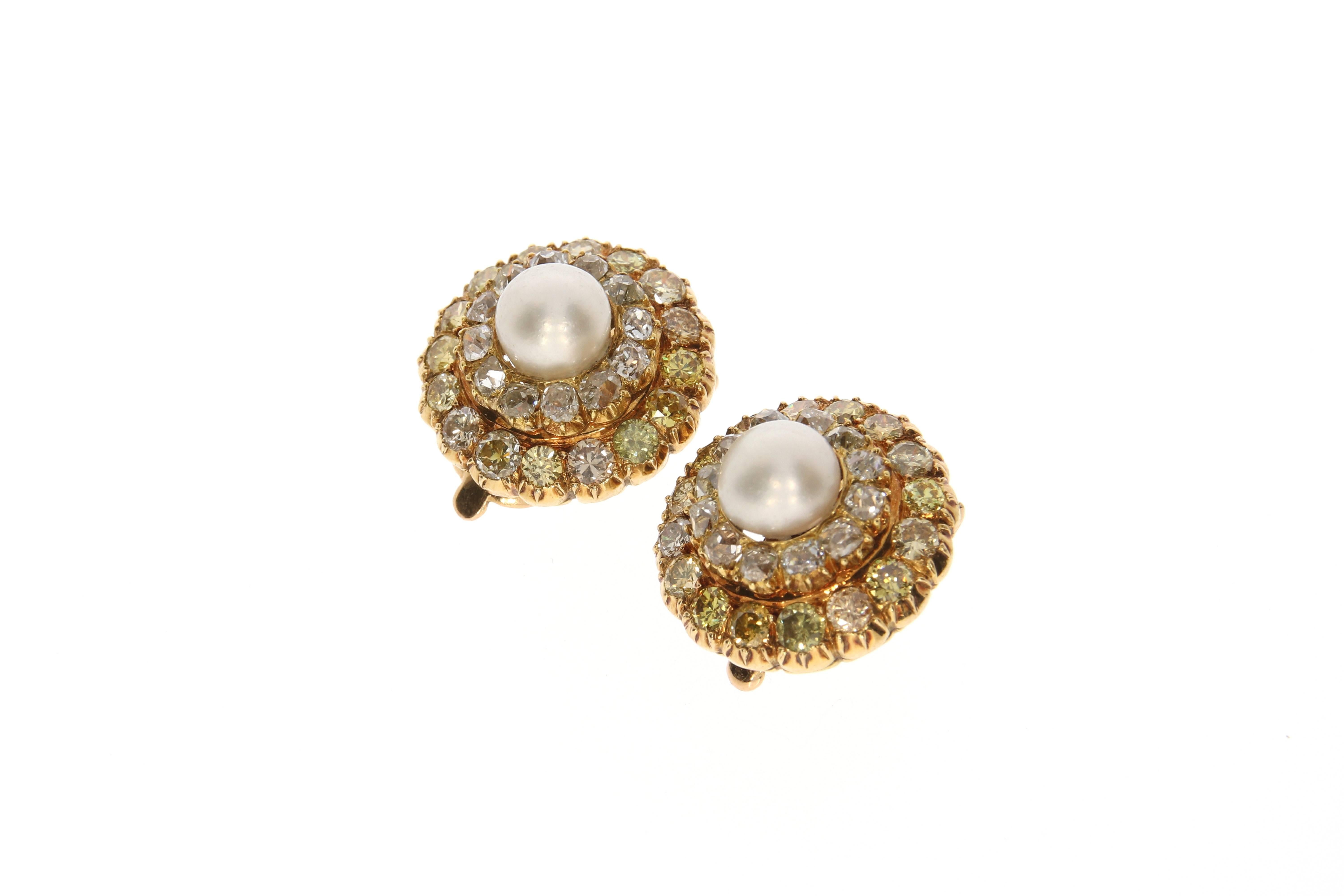 Timeless and delightful ear clips, by René Boivin. Each set to the center with a natural pearl within a double frame of old mine cut diamonds. These 24 greyish and 32 yellow diamonds give a total of approximately 5,10 carats. Rounded off by an 18