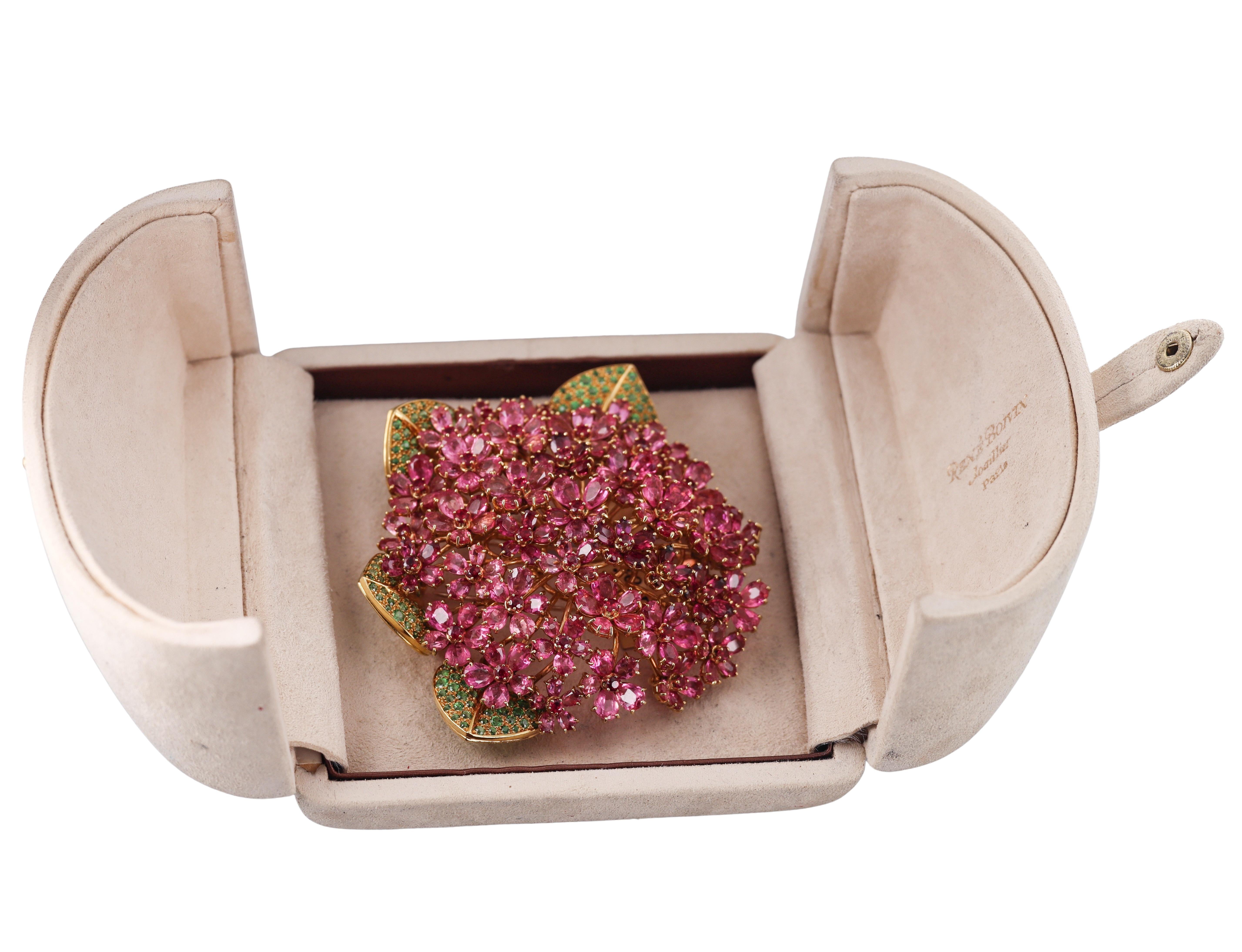 Squisita spilla in oro giallo 18 carati di René Boivin, con petali di fiori di zaffiro rosa, rubini al centro e foglie di granato tsavorite. La spilla misura 3,25