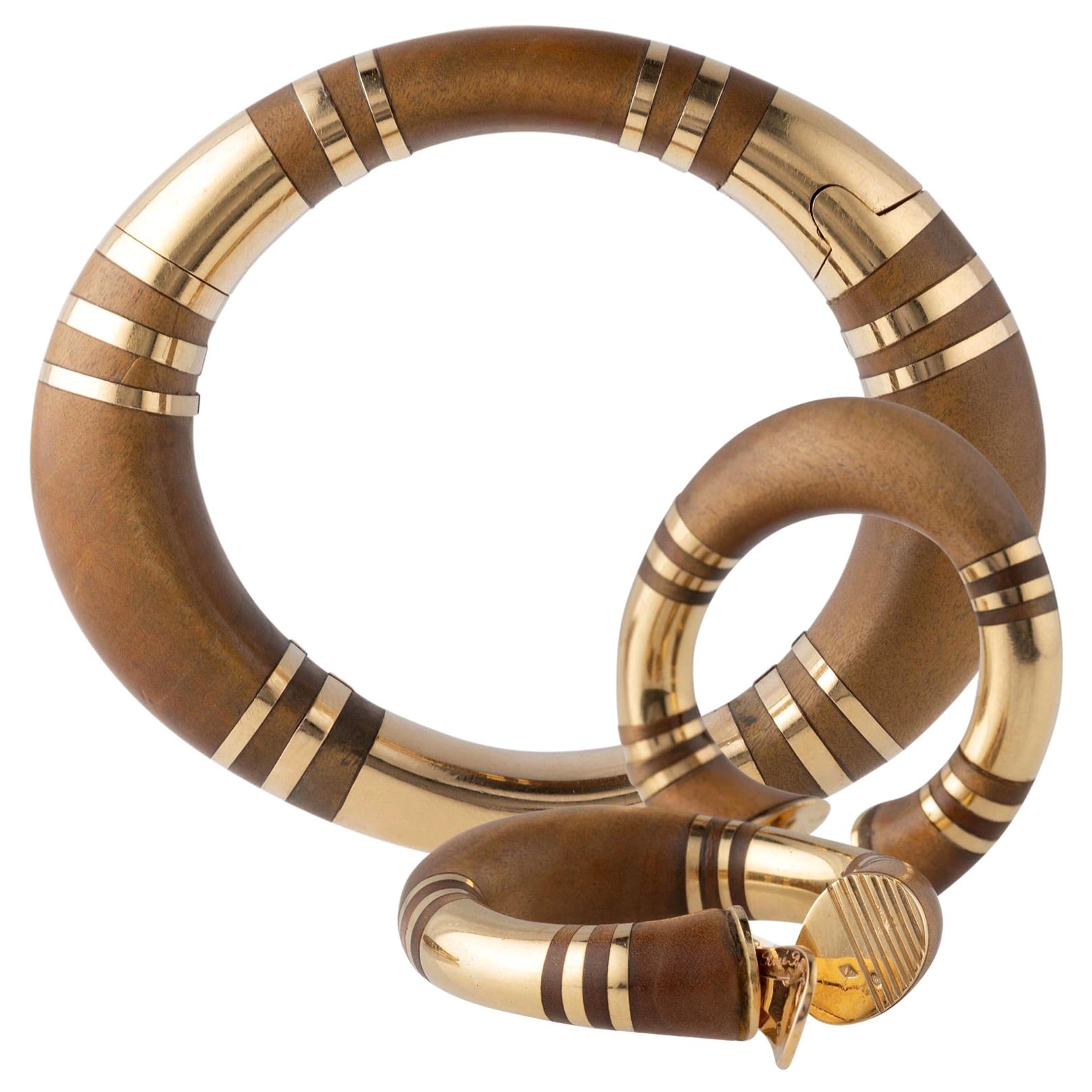 René Boivin set  (openable bracelet and a pair of ear clips) in wood with rings in yellow gold. 
Signed René Boivin. 
Circa 1970
Bracelet length: 18 cm. Width: 5 cm. 
Total weight: 137.5 g.
