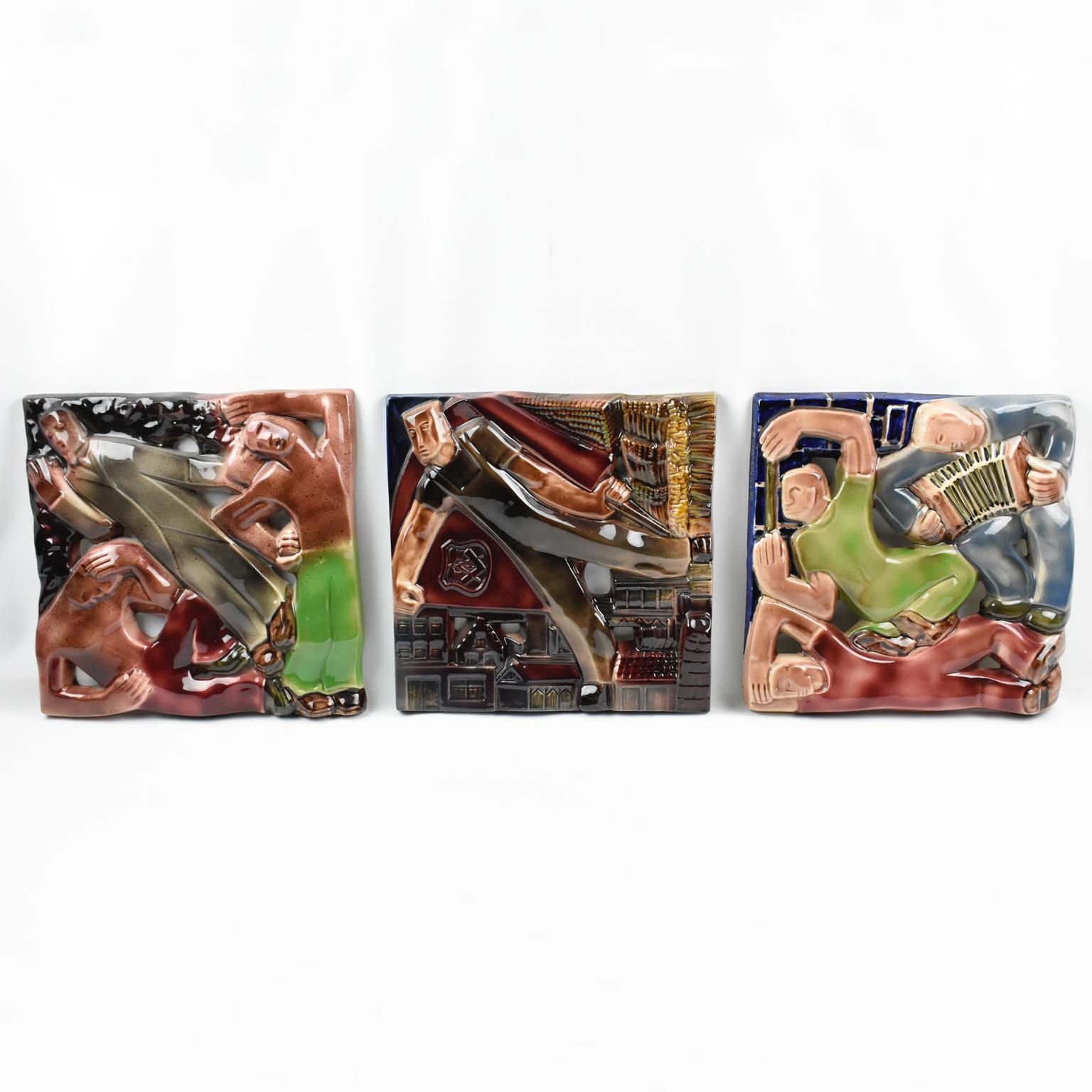 These stunning Rene Boschmans for Coceram cubist style figural ceramic plaques or wall tiles depict industrial, working, and sports scenes. The trio of artwork boasts a cubist design on shiny glazed ceramic with industrial and masonic symbolism.