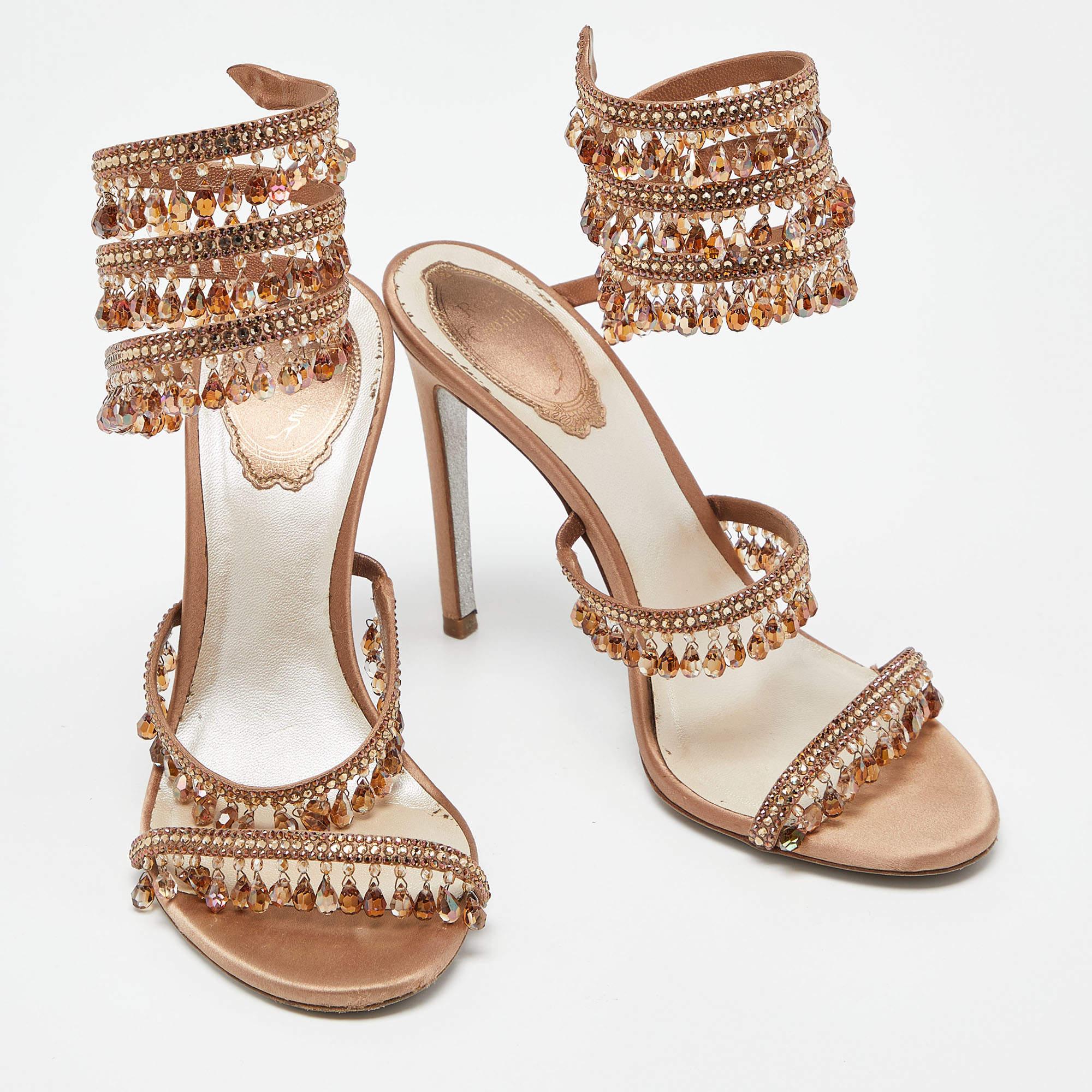 These glamorous and sparkling sandals by René Caovilla are perfect for a special evening. Crafted using white leather, they feature a spiral strap design, rows of dangling embellishments, and 10cm heels.

