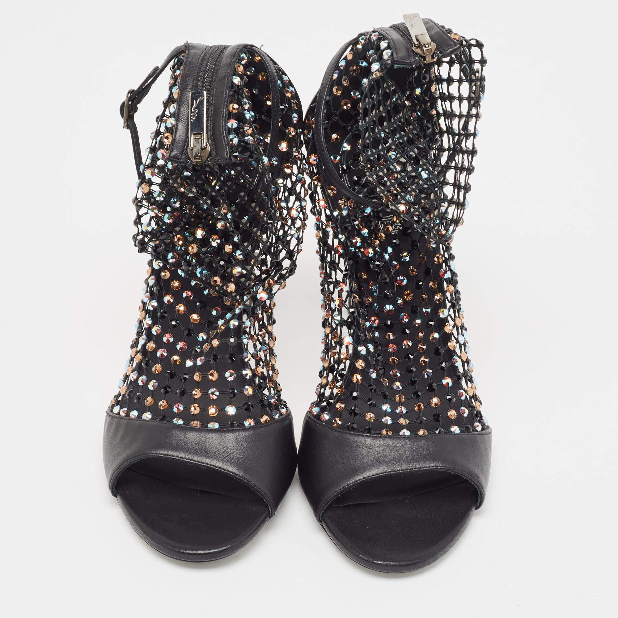 Este elegante par de sandalias de René Caovilla queda aún mejor en los pies. Los zapatos tienen un exterior de cuero y malla de cristal sujeto por cremalleras. Se levantan sobre tacones de aguja.

