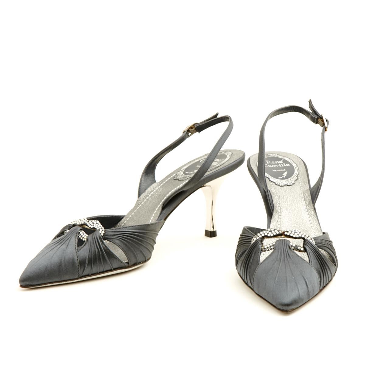 René Caovilla slingback pumps in dark grey satin draped in front around a buckle with a pattern of 2 snakes paved with grey rhinestones, signature glitter sole and silver mirror heels. Size EU37.5 or UK4.5 and US7: 7 cm heel, 24 cm insole (excluding