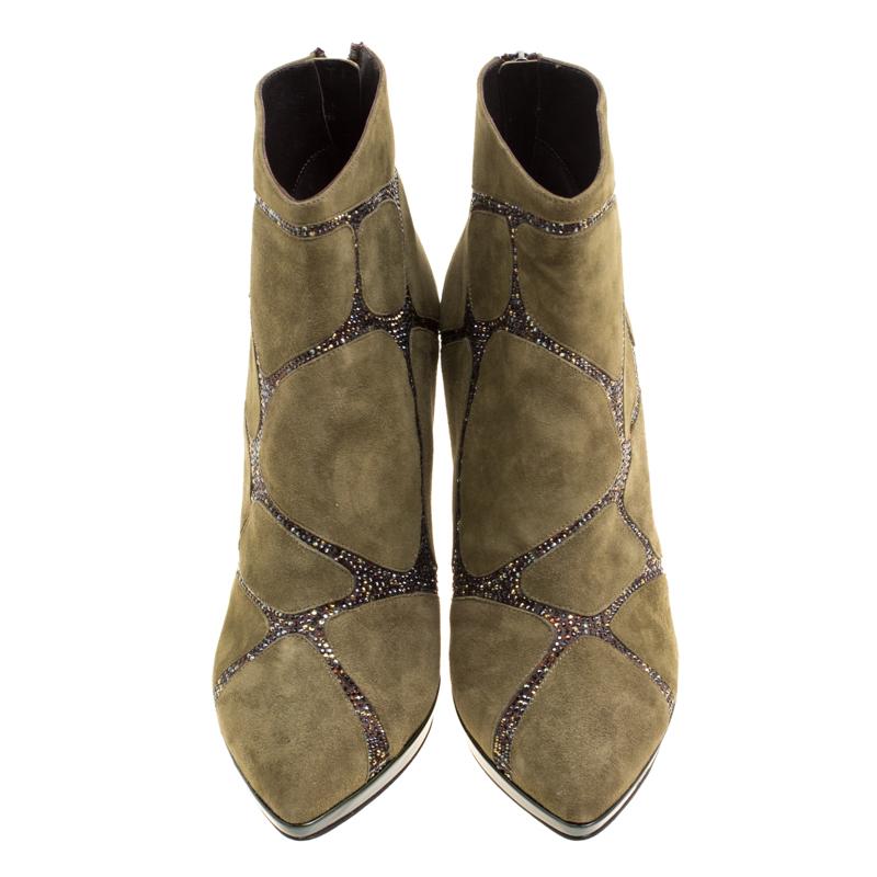 Take your shoe game a notch higher with these ankle boots from René Caovilla. Crafted from suede in a khaki green hue, they are adorned with crystal embellishments on the uppers in an interesting fashion. They feature pointed toes and leather lined