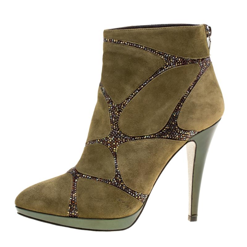 Take your shoe game a notch higher with these ankle boots from René Caovilla. Crafted from suede in a khaki green hue, they are adorned with crystal embellishments on the uppers in an interesting fashion. They feature pointed toes and leather lined