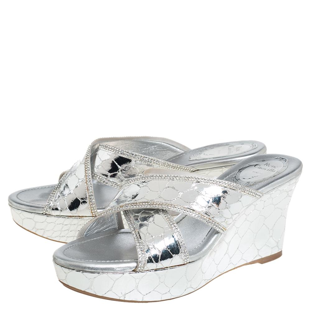 These lovely Rene Caovilla sandals will bring the right amount of style and shine to your feet. They feature cross straps on the vamps made from metallic silver textured leather and 8 cm platform wedge heels. They are pretty and easy to flaunt.

