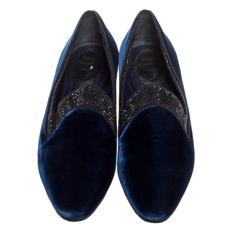 These regal smoking slippers from René Caovilla promise to make you stand out and make an impression like never before. Exuding royalty in navy blue velvet, they feature almond toes and crystal embellishments on the uppers. Leather-lined insoles