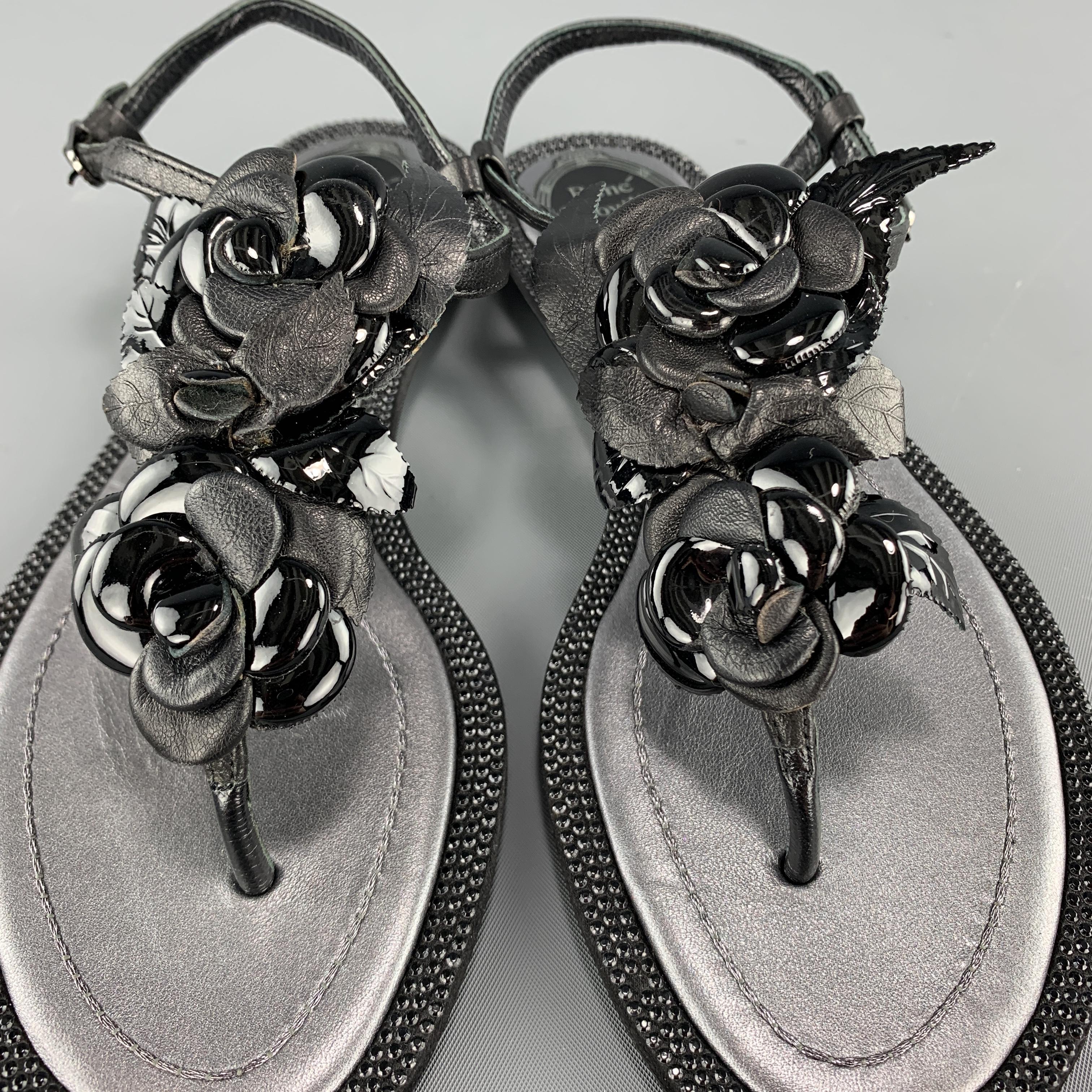 RENE CAOVILLA sandals come in silver metallic leather with crystal studded trim, and ankle harness thong T strap with patent leather rosettes. Made in Italy.

New without Tags.
Marked: IT 34

Outsole: 9.25 x 3.5 in.