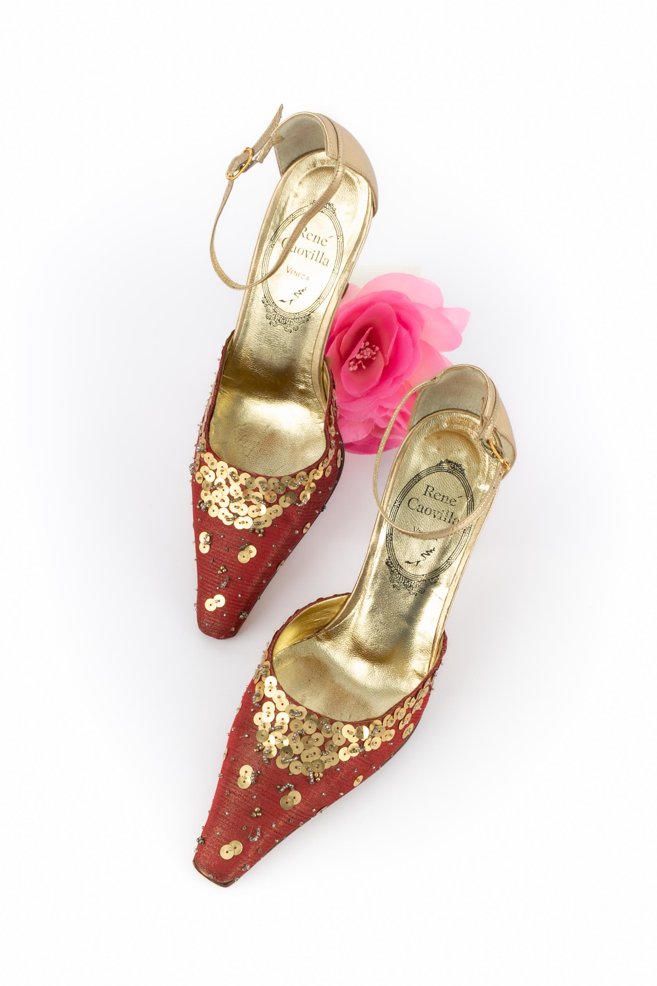 RENE CAOVILLA - (Made in Italy) Stiletti in pelle dorata con tela rossa e fili di lurex dorati, decorati con paillettes e perle. La taglia 5.5 indicata, corrisponde a un 38.5FR.

Condizioni:
Buono stato

Dimensioni:
Altezza del tacco: 8,5