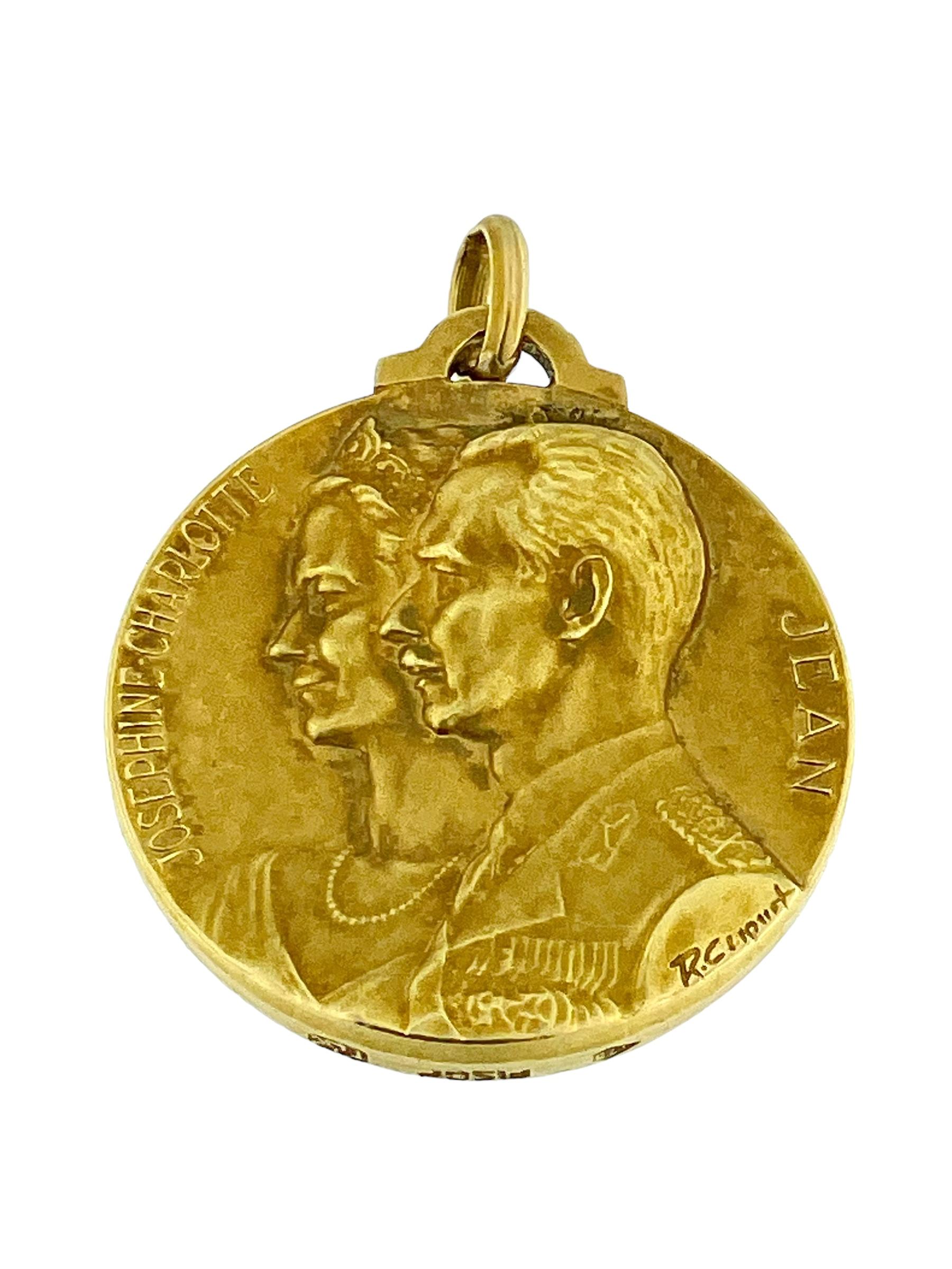 This **René Cliquet Gold Medal Pendant** is a beautifully crafted piece that honors the royal lineage of Luxembourg. Made from 18 karat fine gold, this pendant features intricate detailing on both sides. One side depicts Grand Duke Félix and Grand