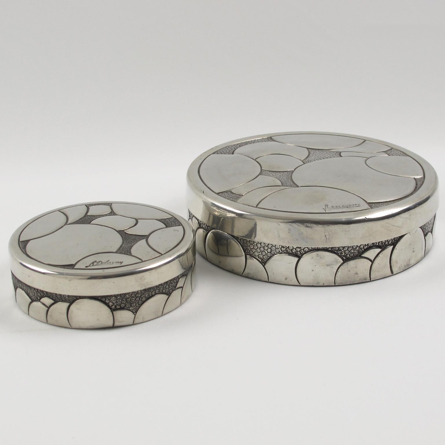 Elegant set of two French Art Deco polished pewter boxes by Rene Delavan. Round lidded shape with carved and embossed typical Art Deco geometric design. Signed 