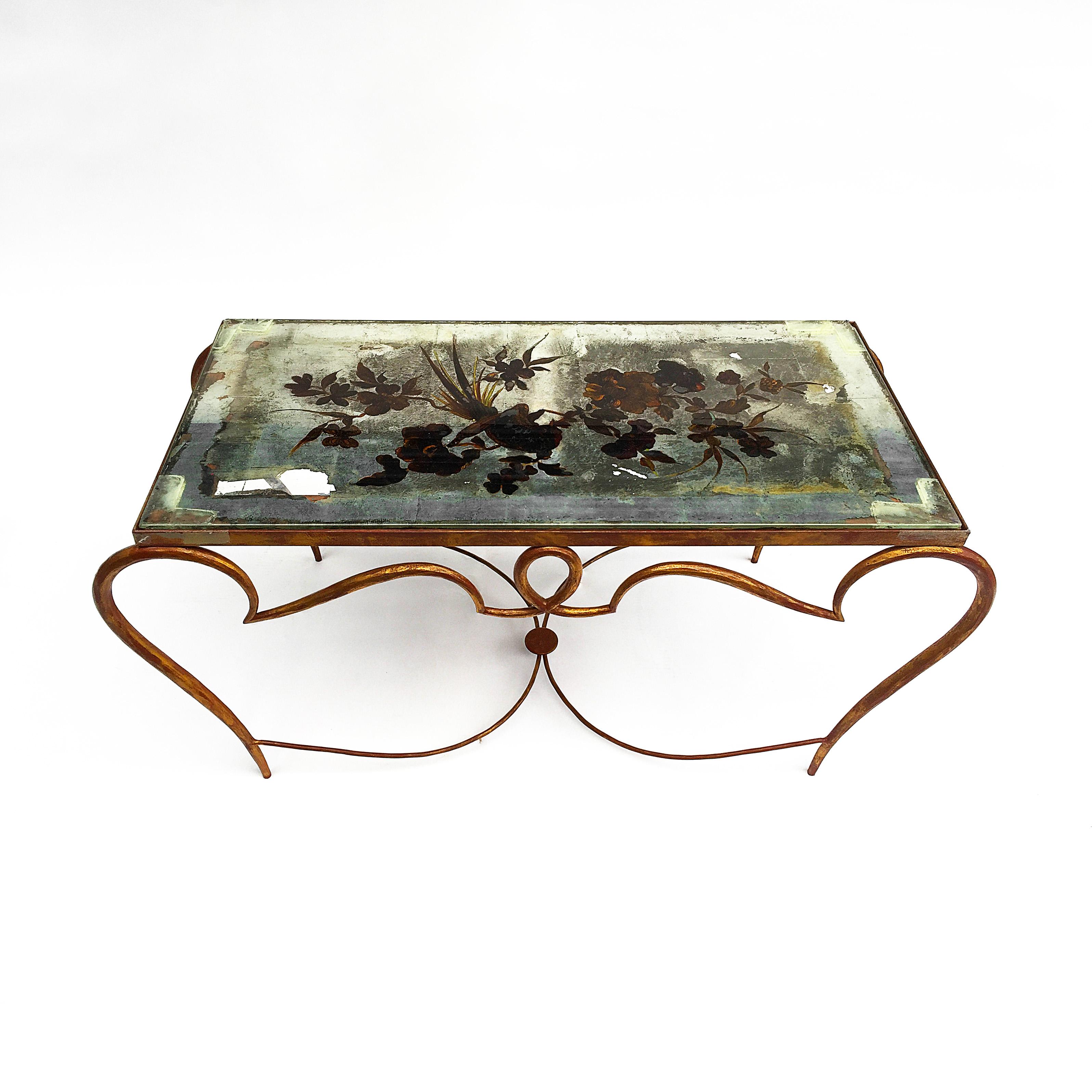 French gilt original cocktail coffee table with its glass by René Drouet. Beautiful forged iron curved gilt legs on red metal surface. Original glass top silver leaf plated surface and gold leaf plated exotic birds and flowers. There is a supported