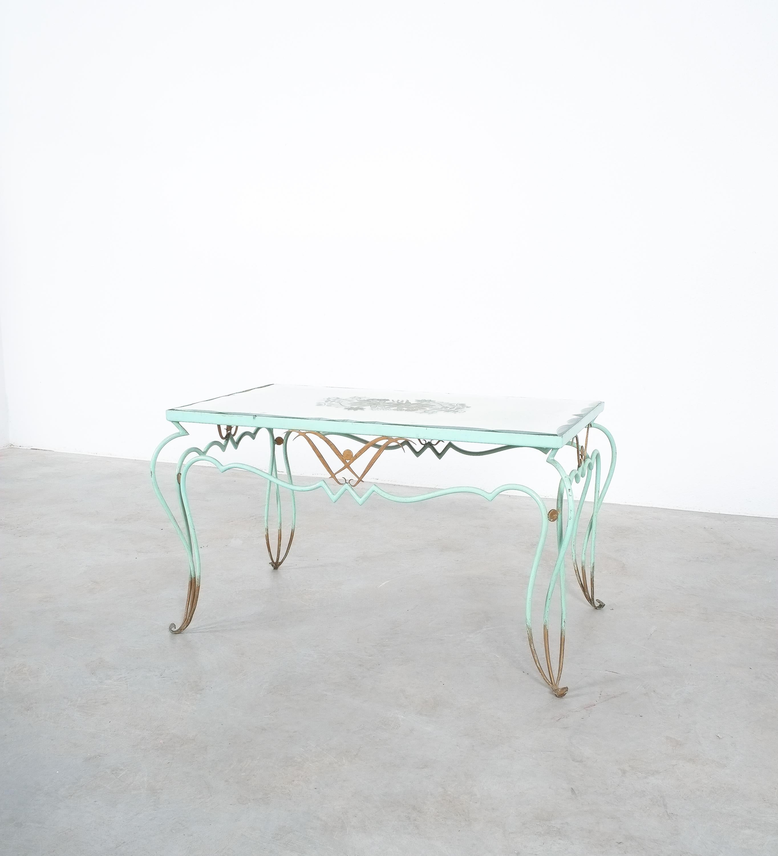 Iconic etched mirrored glass and painted and gilt wrought iron French 1940s coffee table, René Drouet

Elegant handmade wrought iron table in original mint color and golden accents. The original églomisé mirror top was probably created by Pierre