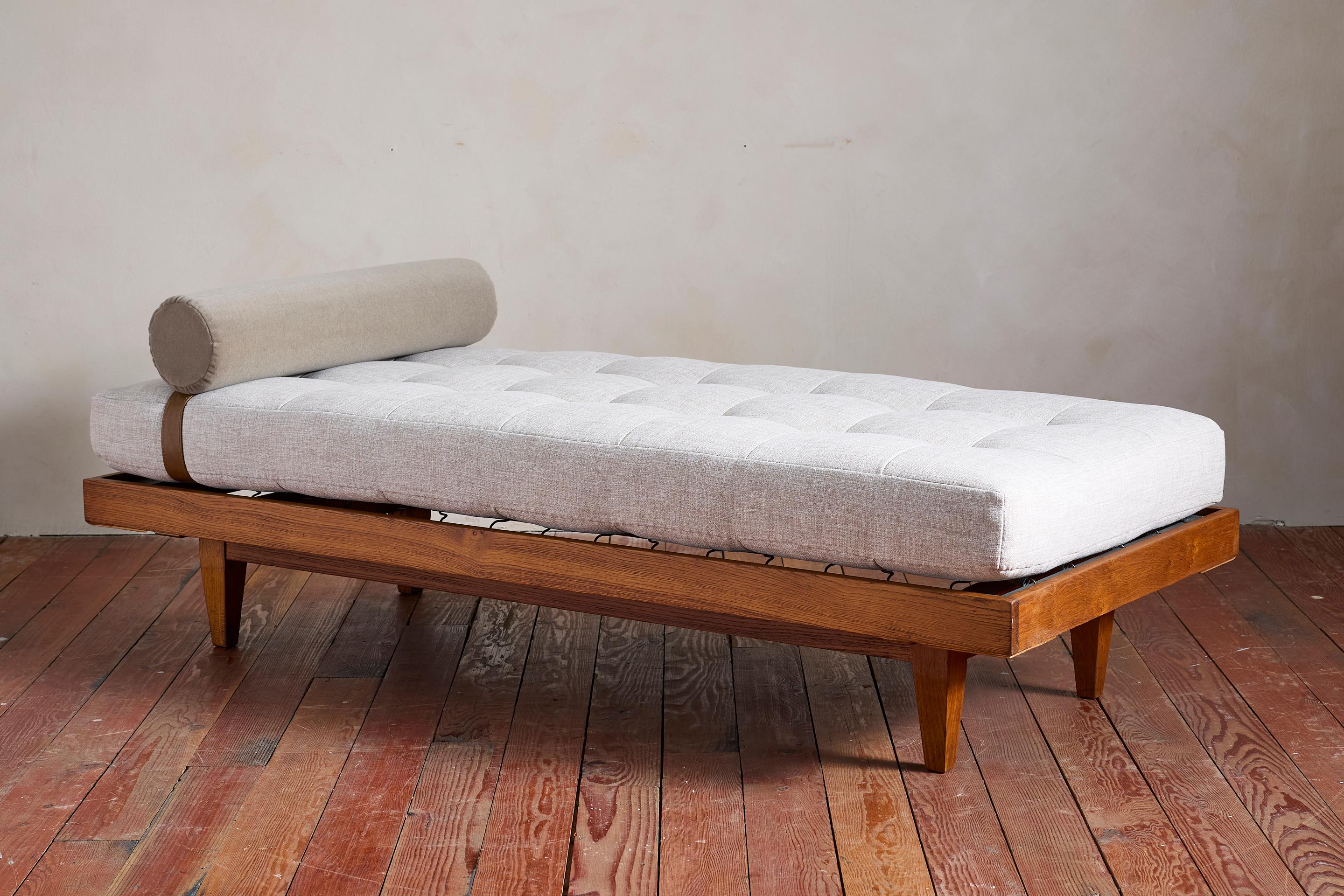 Chic lit de jour attribué à René Gabriel avec un cadre simple en chêne avec une patine magnifique et des pieds encastrés. 

Nouveau coussin rembourré en lin naturel belge avec traversin en mohair taupe et sangle en cuir.