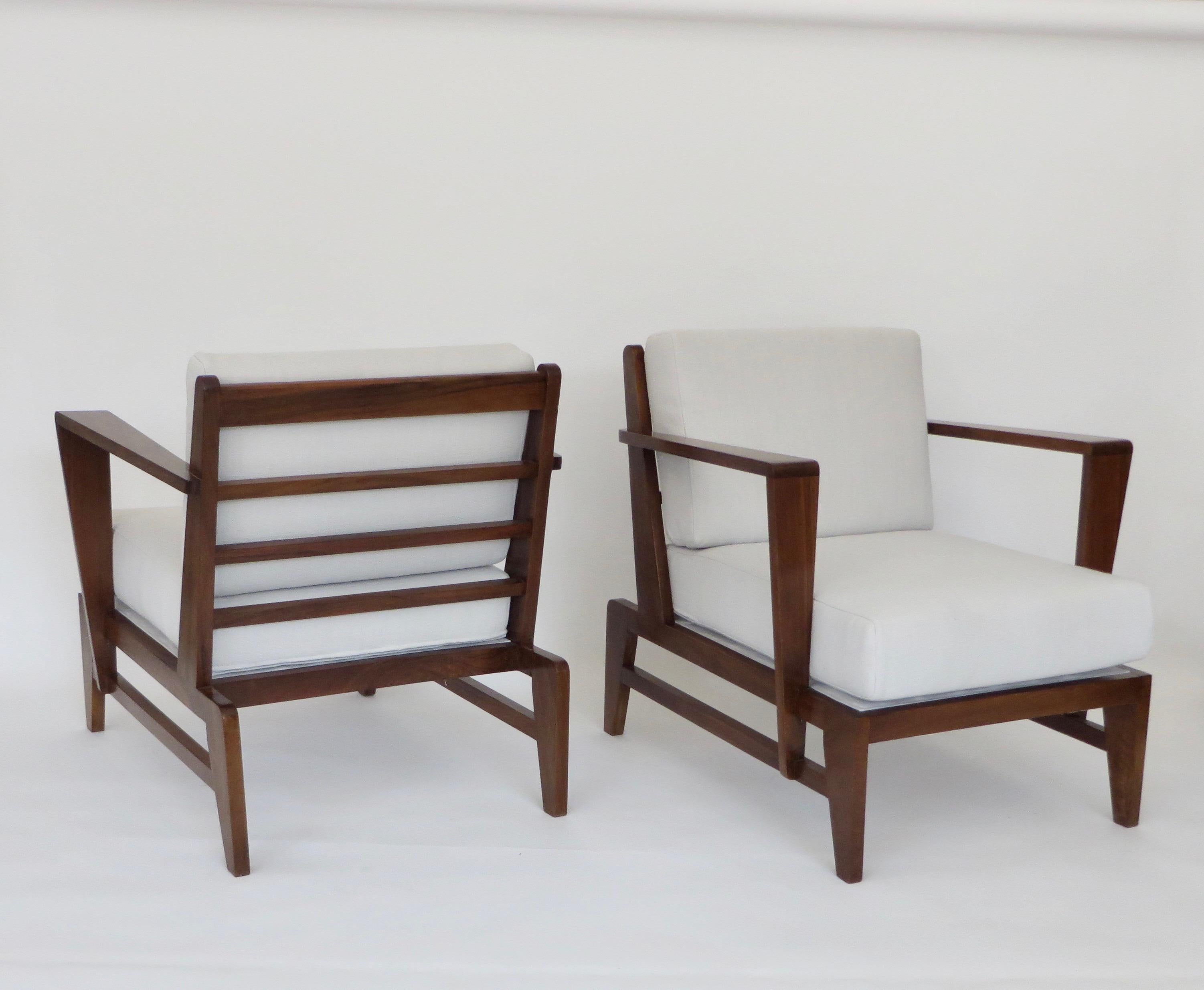 Pair of the most iconic of French cherry wood lounge chairs and armchairs with angled arms and by French designer Rene Gabriel.
Newly upholstered and new cushions done in a cream white French linen with original under springs.
The springs are