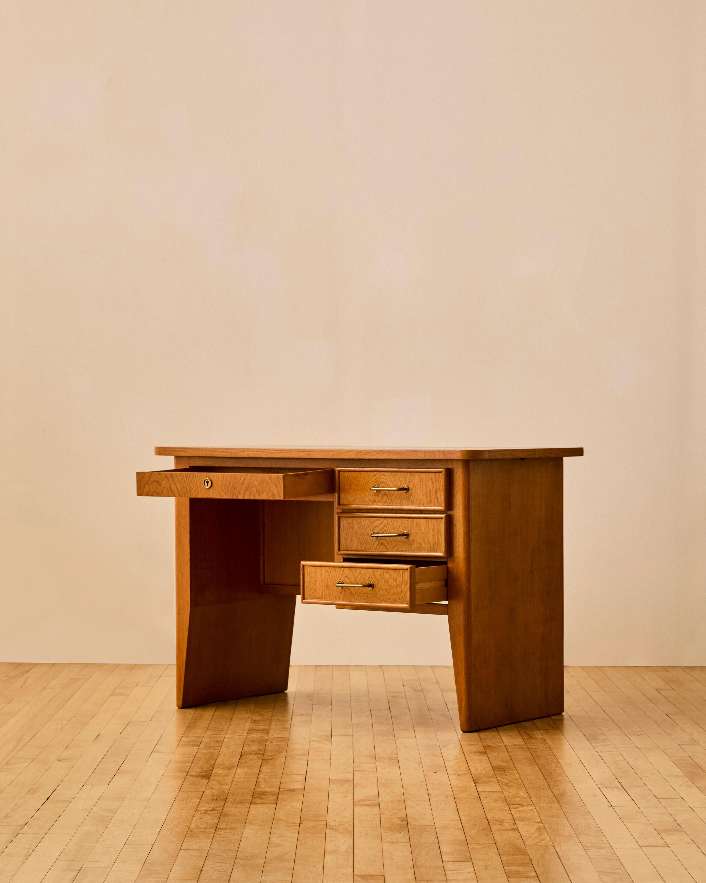 Rene Gabriel oak desk with bronze hardware featuring four drawers and a bookshelf on the visitor's side. Branded manufacturer's mark to interior drawer with 'Creation Rene Gabriel - Edition J. Lieuvin'.