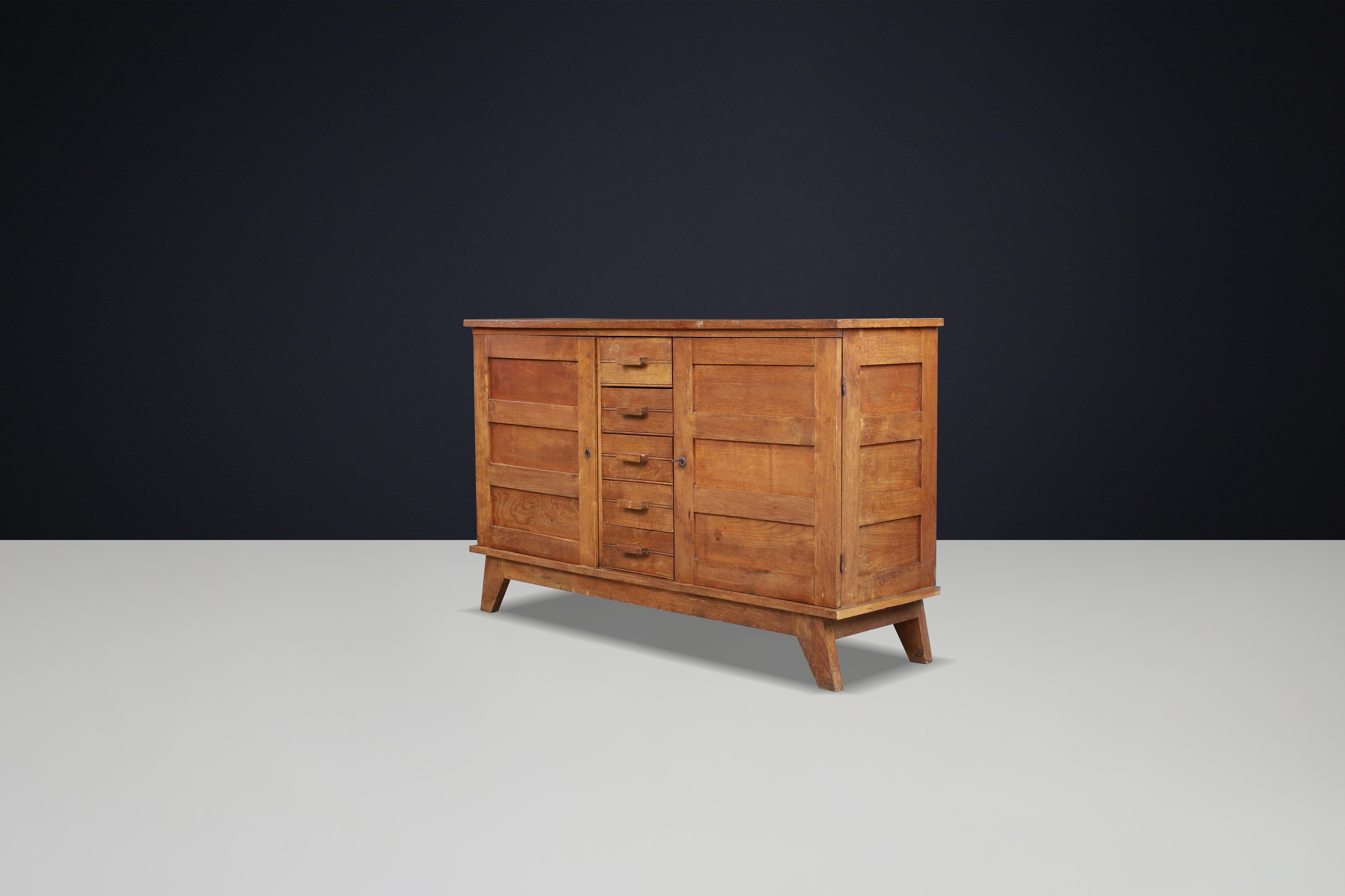 Buffet en chêne patiné René Gabriel, France, années 1940

Ce buffet du milieu du siècle, fabriqué en chêne français patiné, a été conçu par René Gabriel dans les années 1940 en France. Il faisait partie d'une collection de mobilier d'urgence créée