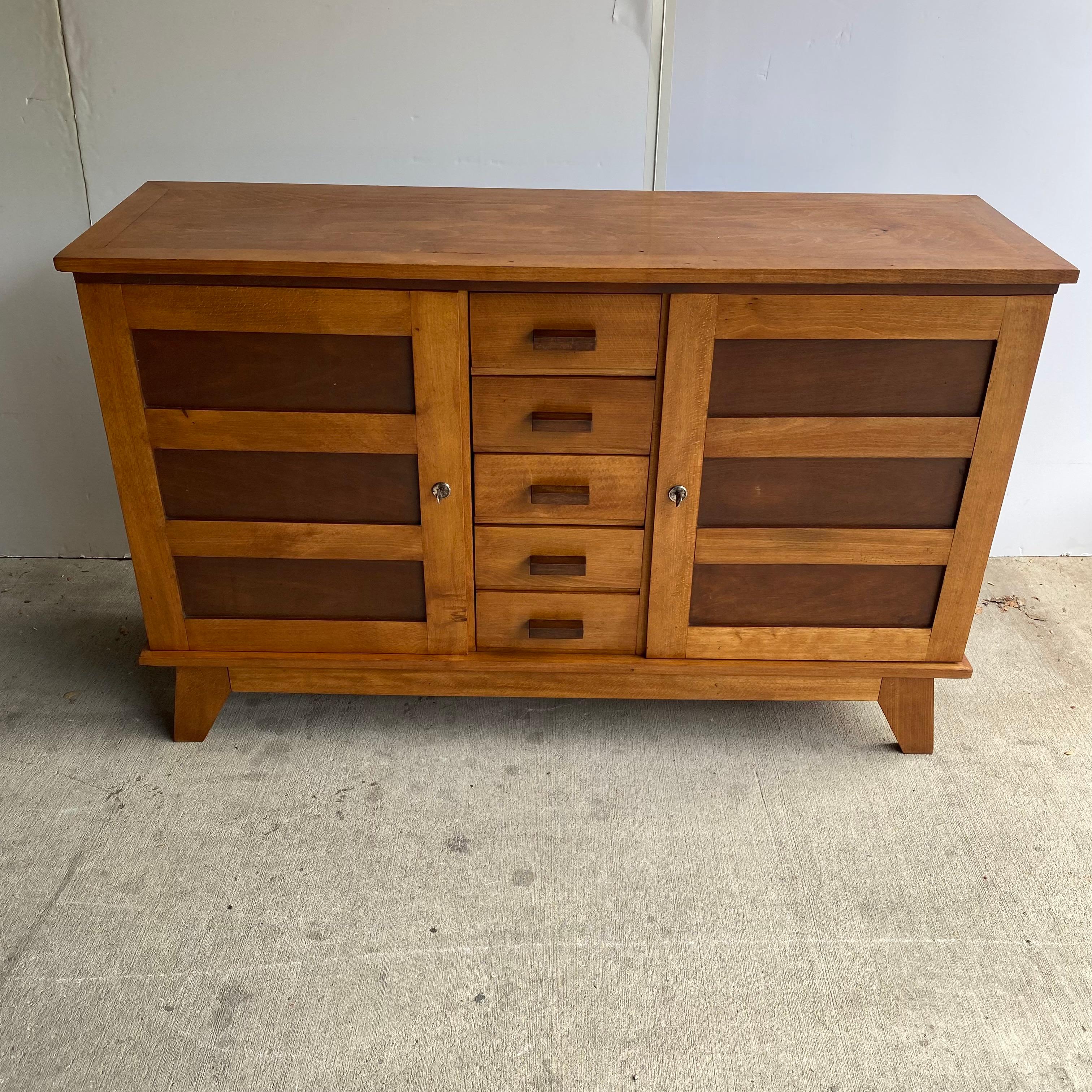 A collectible piece of furniture by Rene Gabriel, the designer commissioned to rebuild the city of La Havre after WW II. Features two doors and 5 drawers in his sought after two tone oak cabinet style. A strong expression of the early Mid-Century