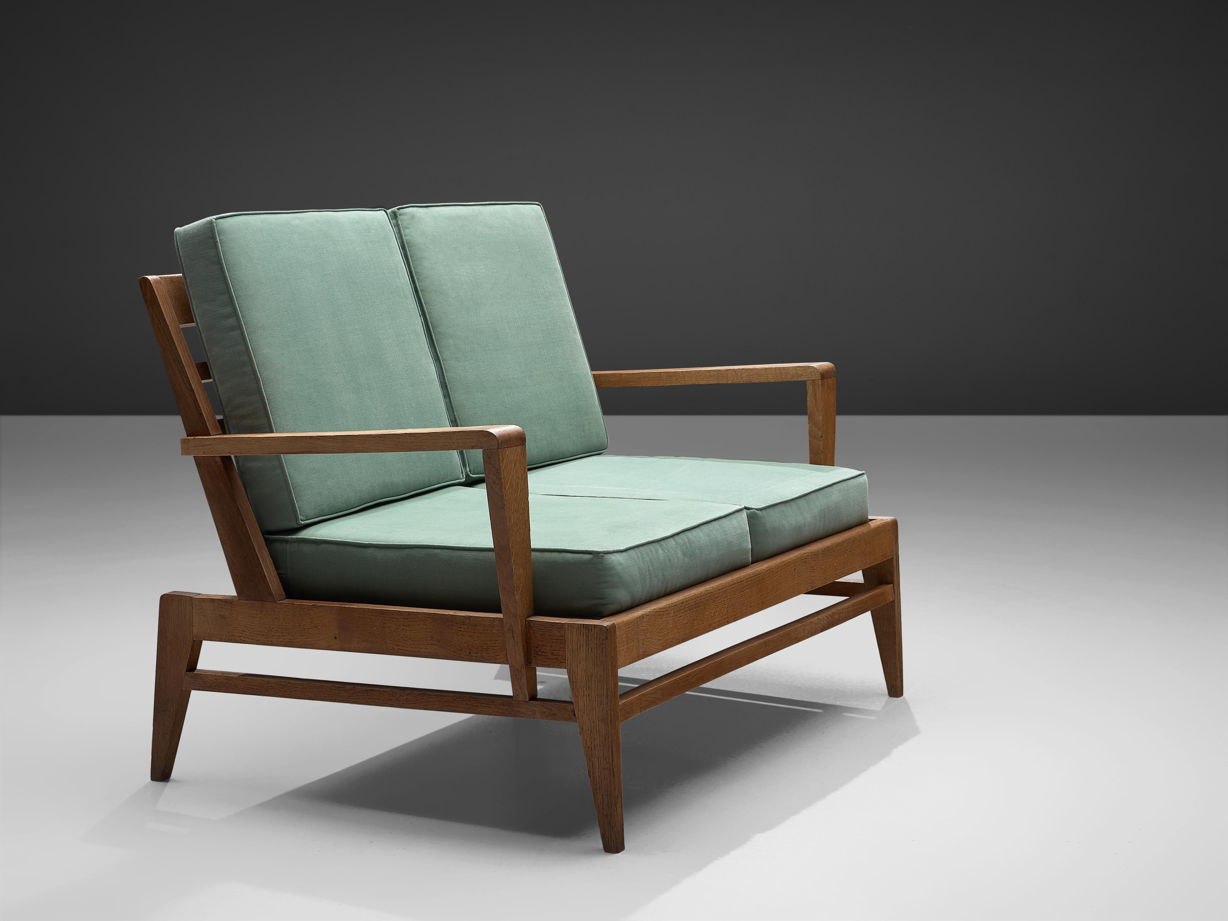 Rene Gabriel for Lieuvin, settee in oak and mint green fabric, France, design circa 1946.

This hard-to-find sofa is designed by the French artist René Gabriel who is known for his constructivist approach to furniture design. This model was