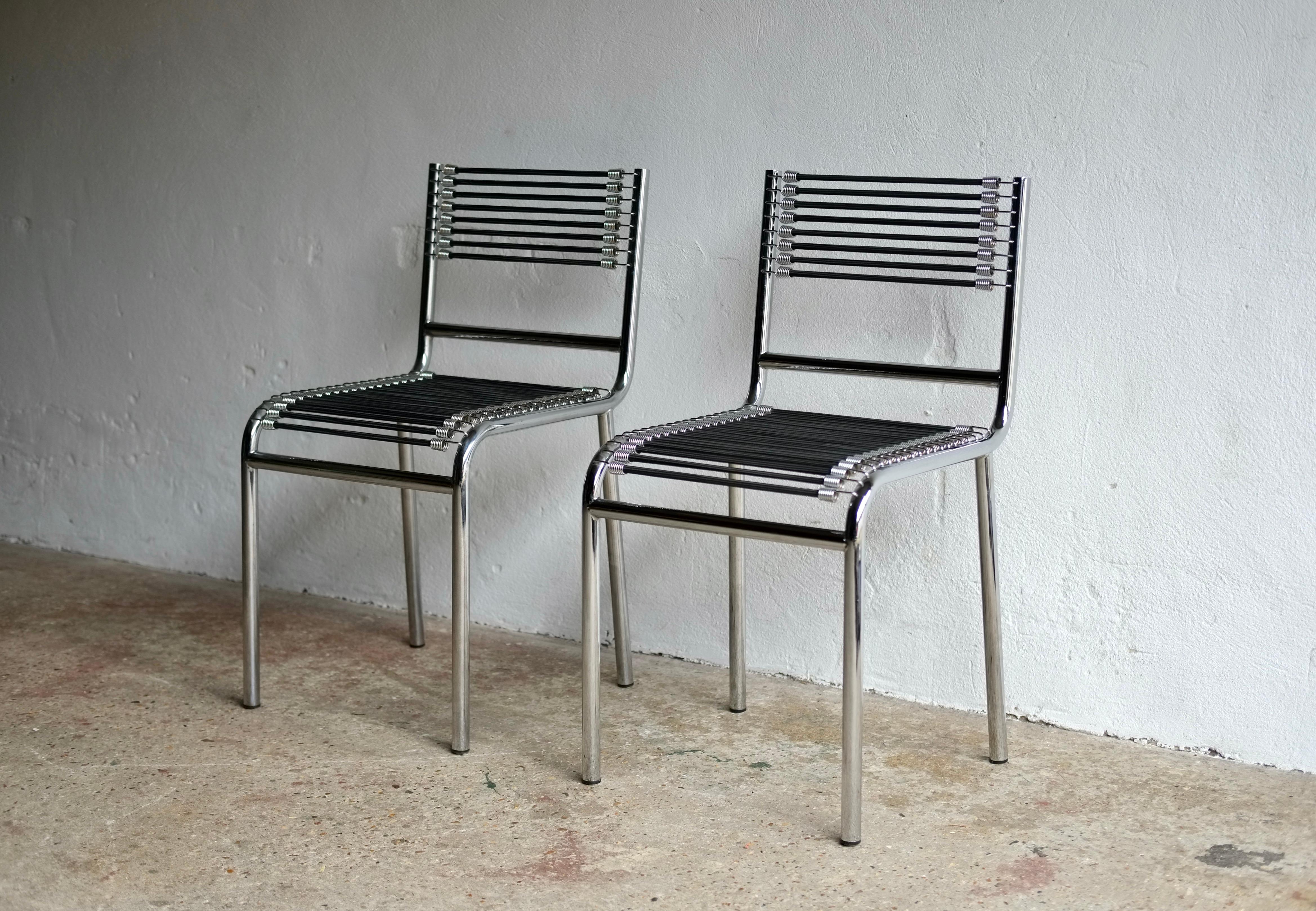 A pair of model 101 Sandows dining chairs designed by French architect Rene Herbst in 1928 and reproduced in the 1990's. 

First exhibited at the Paris Salon d'Automne des Artistes Decorateurs in 1929.

Nickel-plated steel tube and elastic rubber