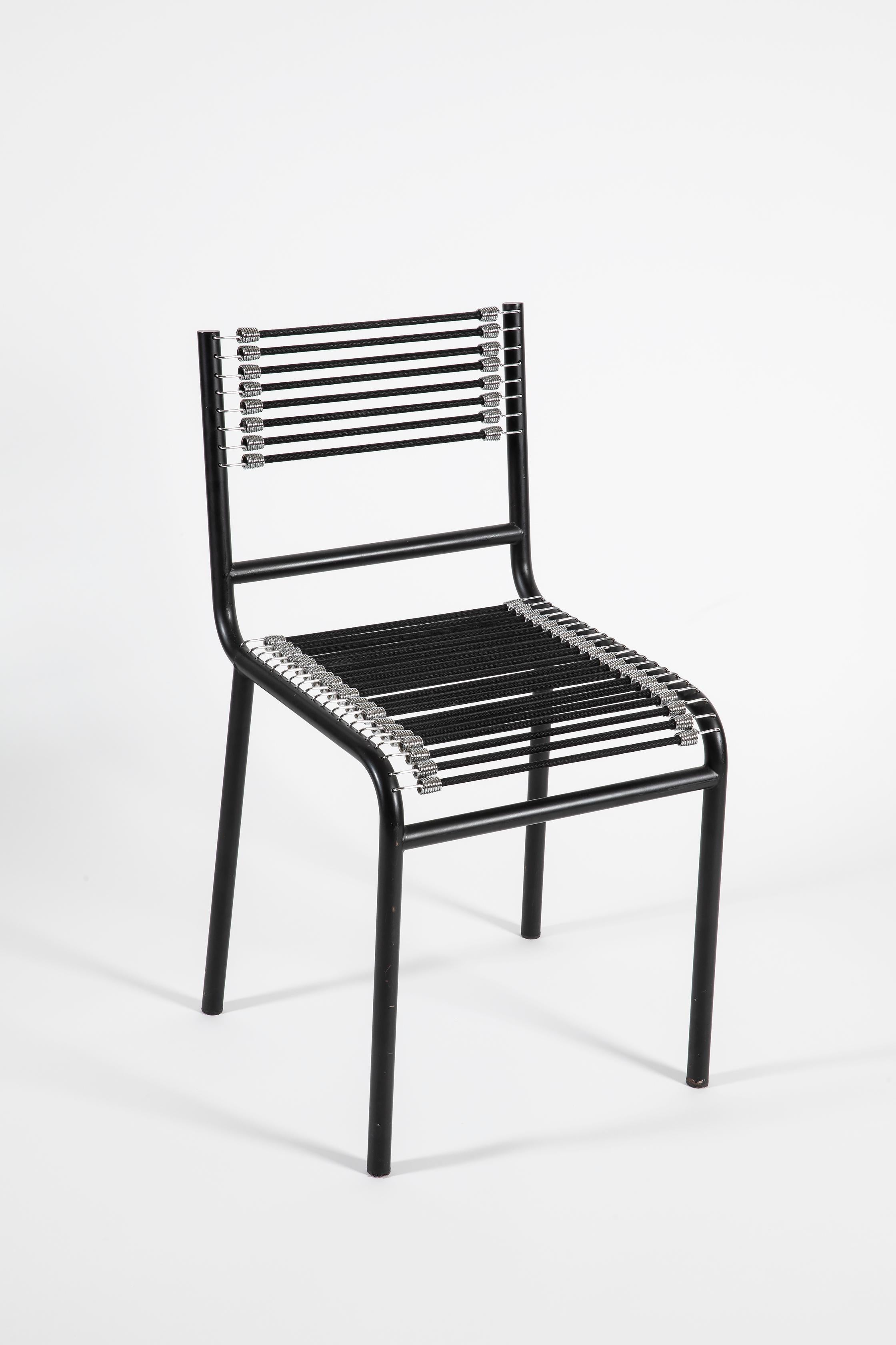 Ensemble de quatre chaises Sandow de René Herbst. Structure en tube d'acier laqué noir et cordon en caoutchouc élastique. Le design original date de 1928 et a été présenté au Salon d'Automne de 1929. Dans les années 1980, la célèbre usine italienne