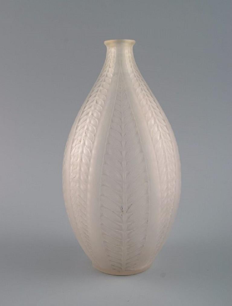 René Lalique (1860-1945), France. 
Acacia vase in mouth-blown art glass with leaves in relief. 
1920s / 30s.
Measures: 20 x 11 cm.
In excellent condition.
Stamped: R. Lalique.
