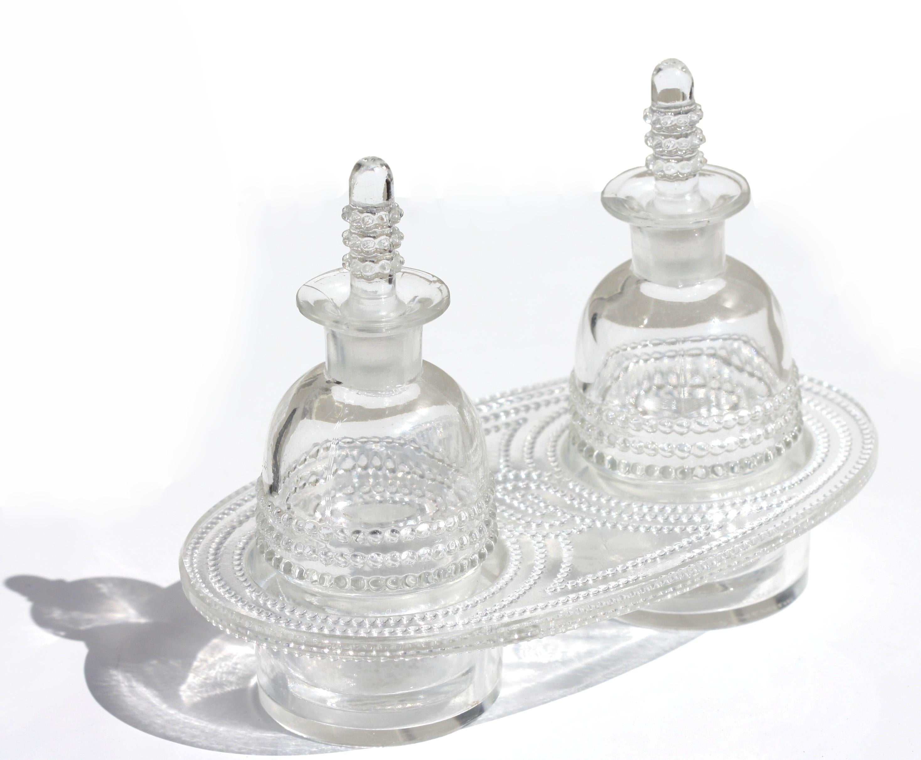 Rene Lalique (1860-1945)
Nippon et Tokyo
A R.Lalique glass oil and vinegar set
circa 1933
Marcilhac 3896
4.5 in. (11.43 cm) high
6.25 in. (15.88 cm.) wide
acid stamped R. Lalique.
 