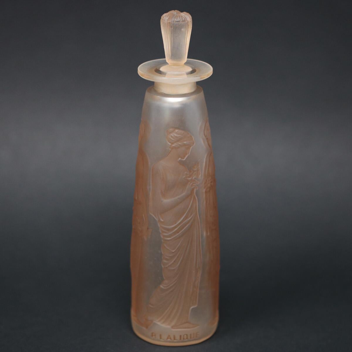 René Lalique clear and frosted, sepia stained glass perfume bottle. 'Ambre antique' design. This design features robed maidens, holding flower bouquets. Moulded makers mark, 'R LALIQUE'. Engraved letters to the underside. Book reference: Marcilhac