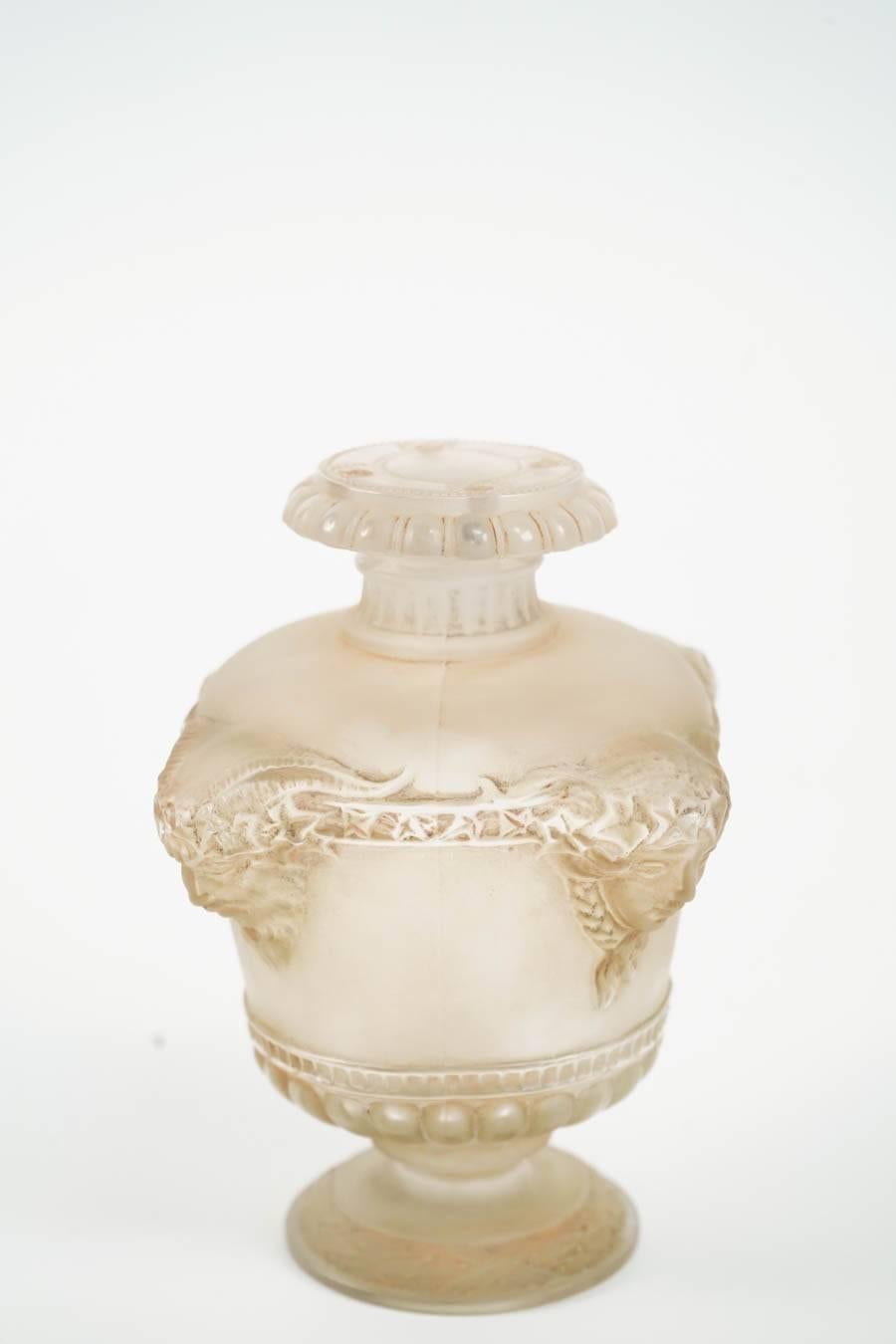 Footed urn Art Nouveau style frosted glass container having four mythical Faun heads in high relief,
circa 1925.
“BOUQUET DE FAUNE” Flacon en verre, en forme de vase “Médicis” décoré par des godrons en partie basse et par quatre têtes de faunes