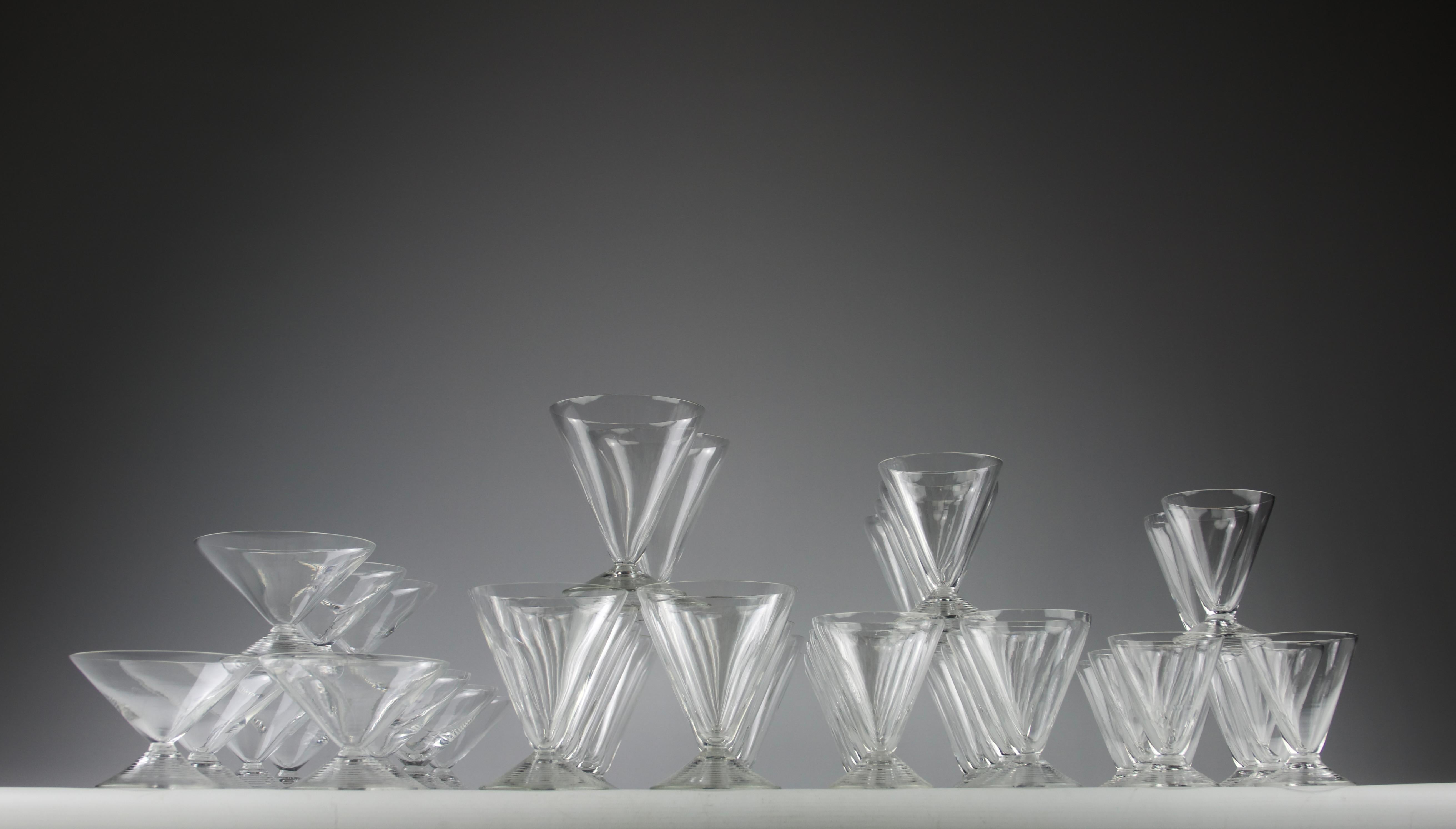 Superbo e rarissimo servizio di bicchieri Arbois disegnato da René Lalique per la Maison Lalique nel 1937. Bellissime decorazioni di una struttura a coste sul piede dall'aspetto di increspature circolari che si colloca a metà tra l'art déco e il
