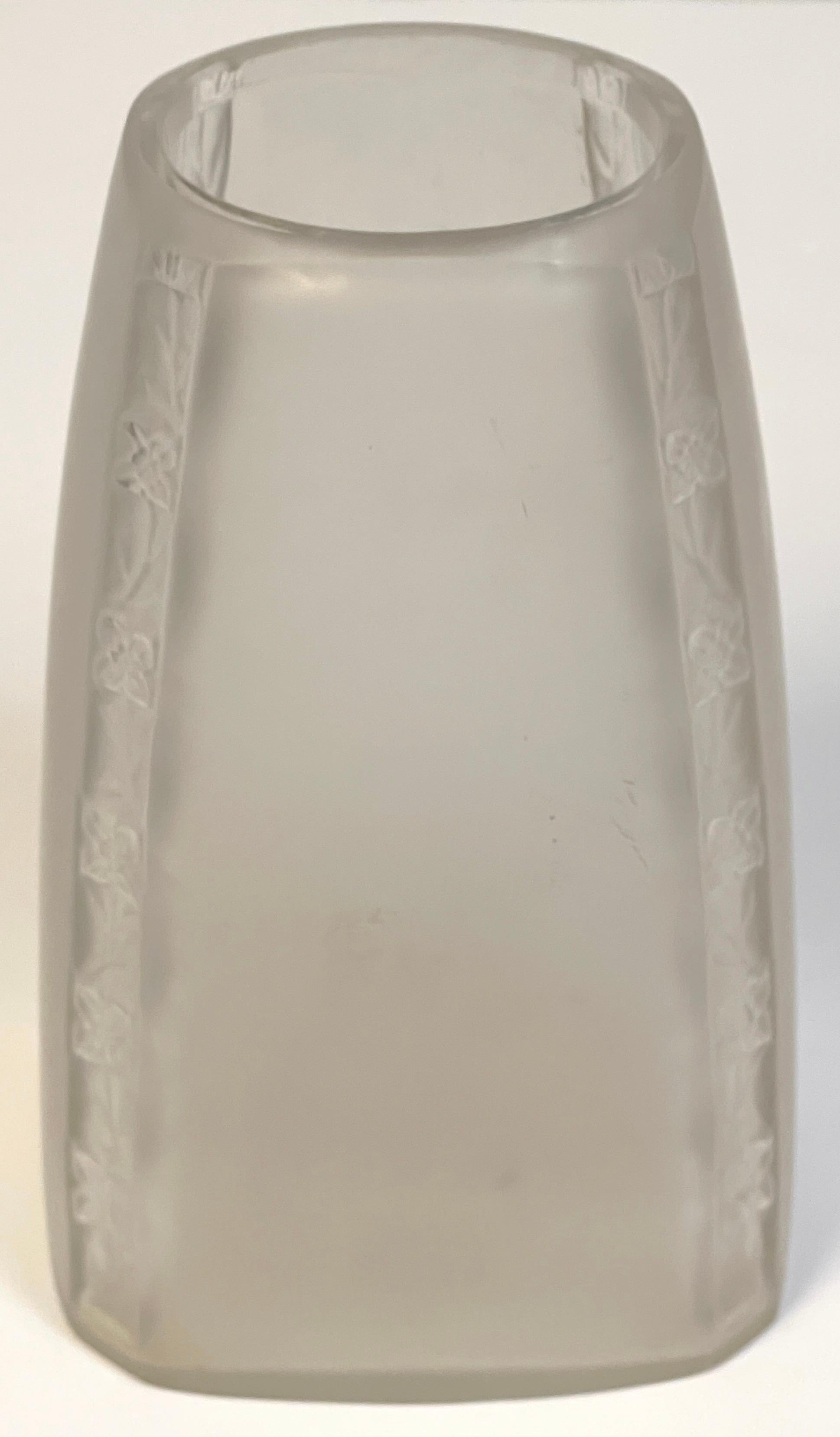 Rene Lalique Art Deco Glass Vase
France, Circa 1920s

A unique period subtle work by Rene Lalique, of square tapering form, with four flowerhead and vine columns at each corner. Signed with early 'LALIAQUE' bold all capital lettered signature.   

