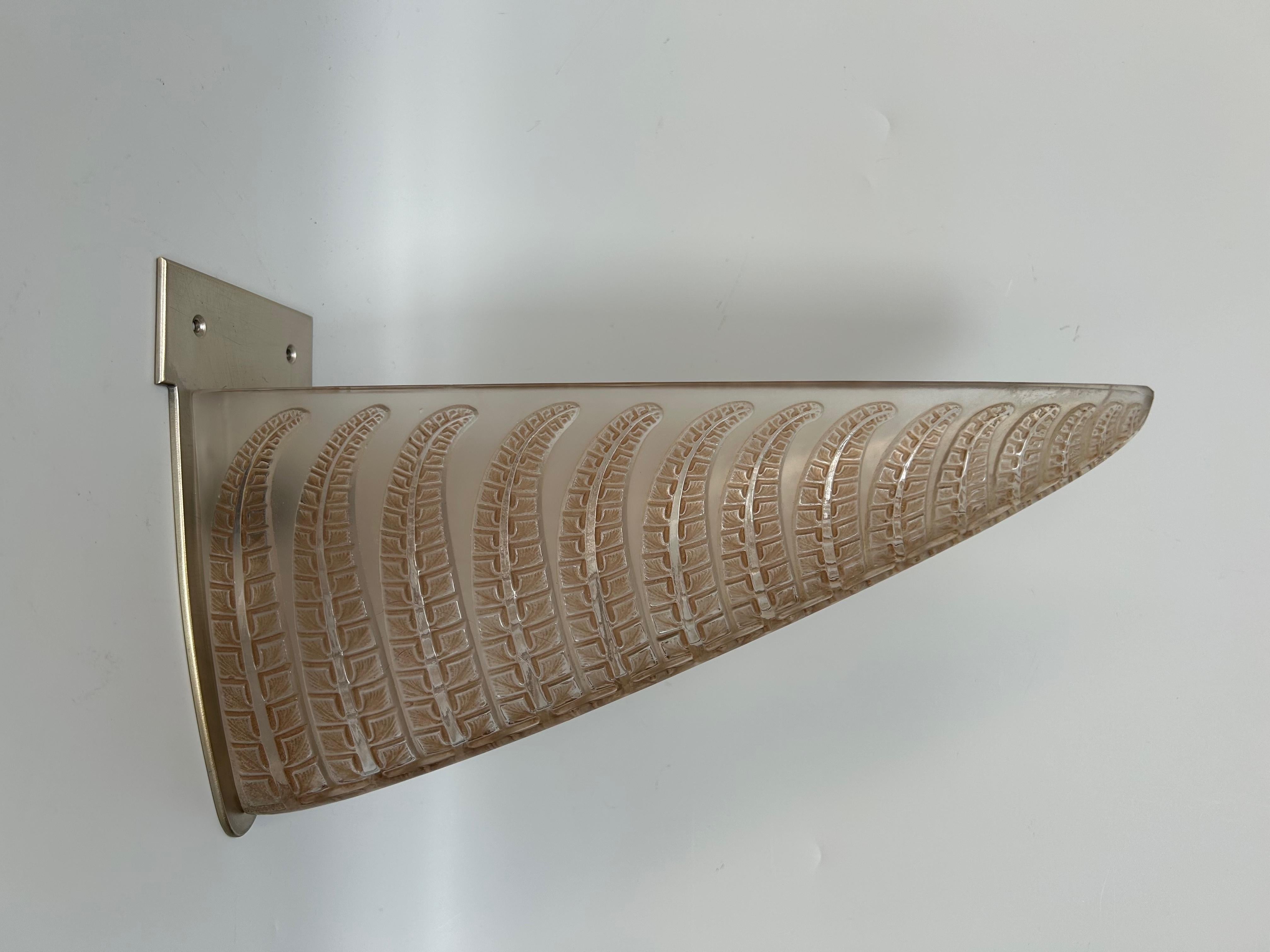 Lámpara de pared Art decó de René Lalique, modelo fougère, creada el 9 de enero de 1924.
Publicado de 1924 a 1936.
 En vidrio moldeado prensado blanco con pátina marrón.
El aplique tiene una grieta en los niveles de fijación (fotos).
La parte con la