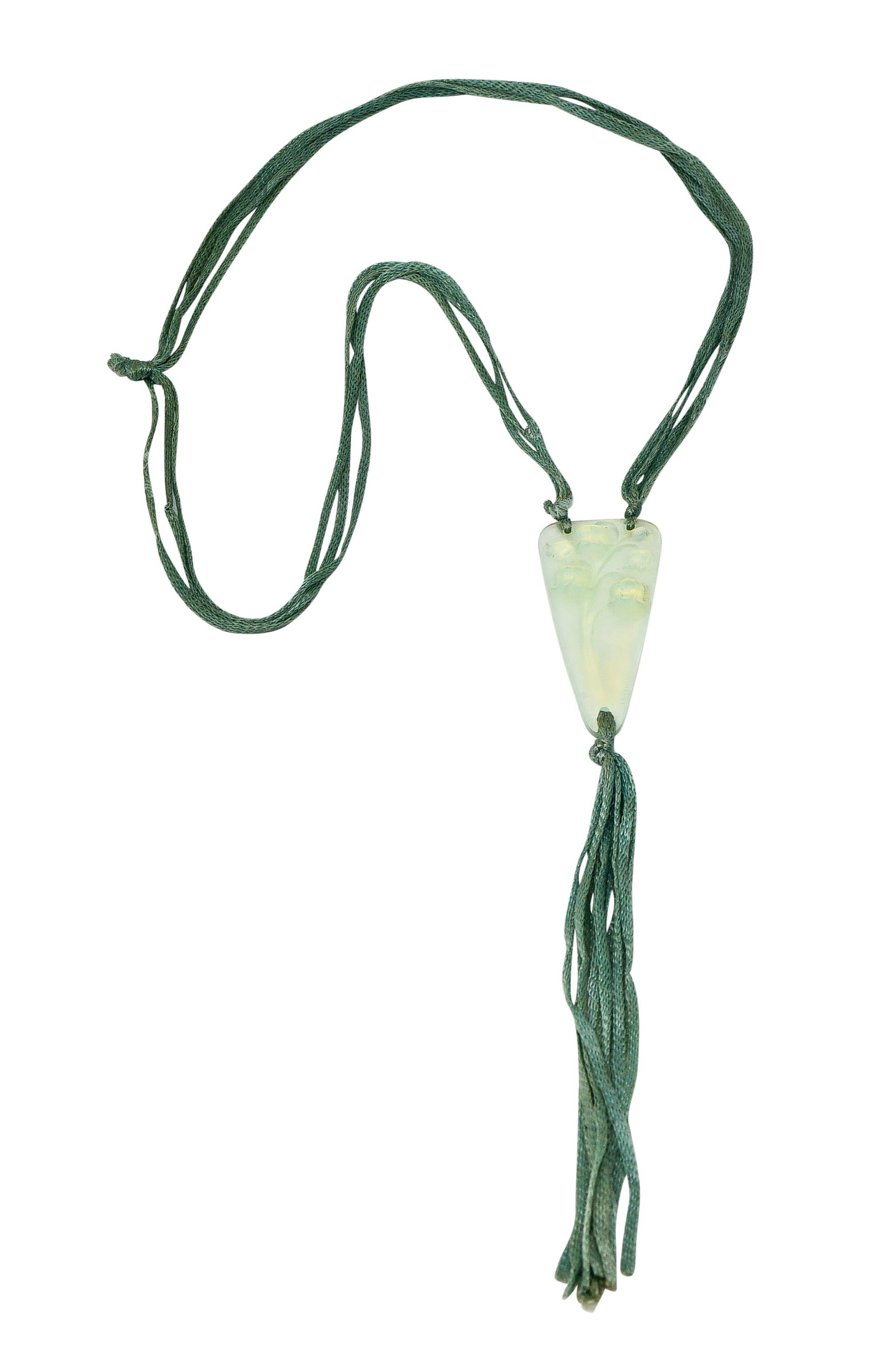 Multi-strand style necklace with four cords of braided silk; light bluish-green in color with wear consistent with age

Centering a triangular frosted glass pendant, highly rendered to depict lily of the valley florals; symbolic of
