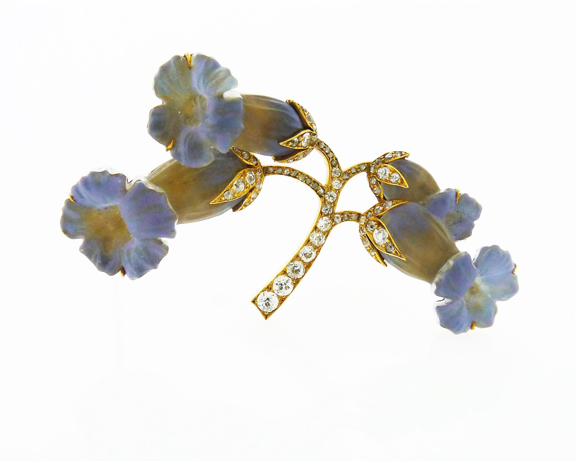 René Lalique (1860-1945), the indisputable genius of Art Nouveau taking form botanical and feminine inspiration to create this beautiful brooch.

Designed as a spray of daffodils composed of carved bluish gray glass,
the stems set with rose-cut