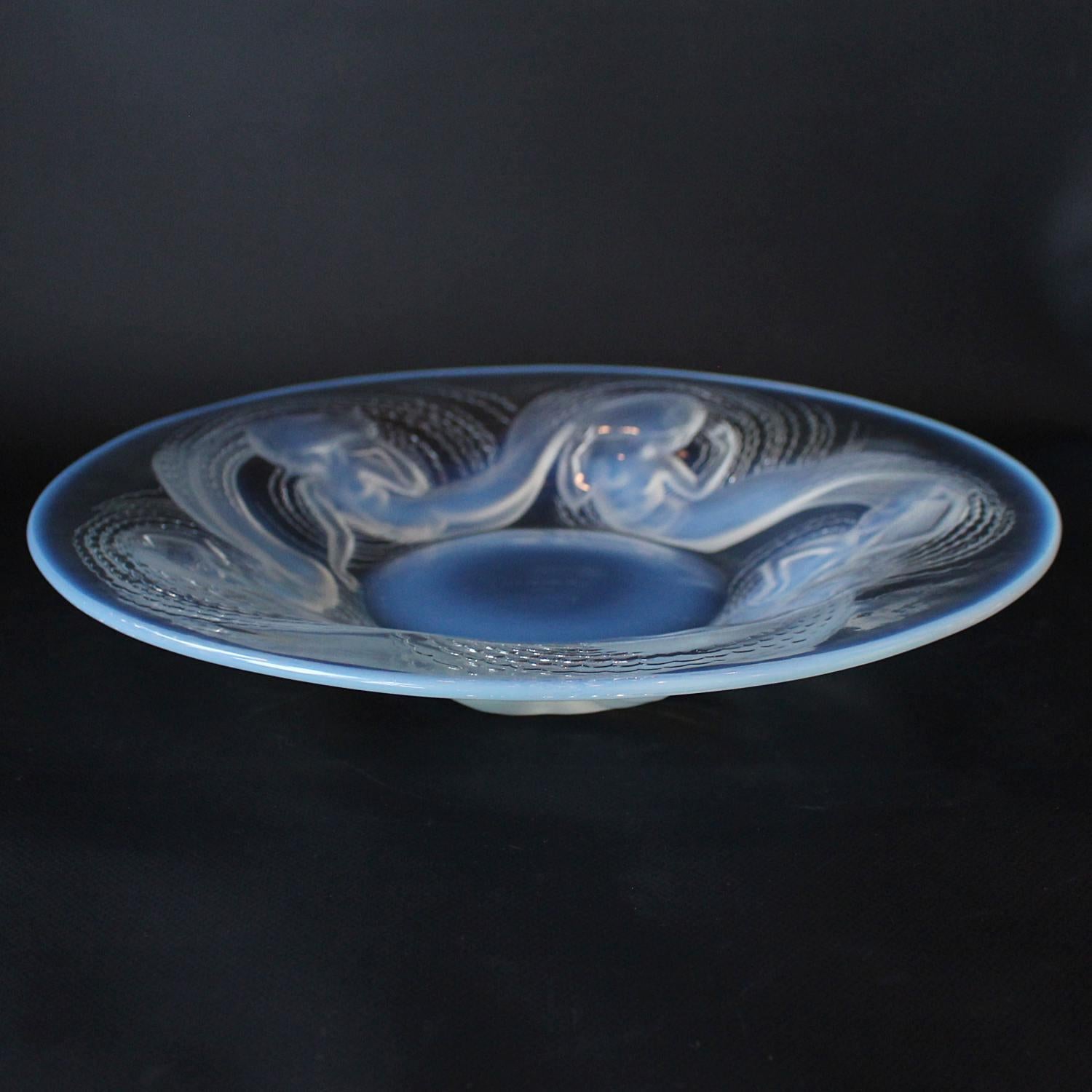 Calypso, an Art Deco, opalescent and clear glass coupe charger. Decorated with reverse raised swirling water nymphs. 

Stencil etched R Lalique France to underside.

Literature: Marcilhac Catalogue Raisonné de L'Œuvre de Verre
