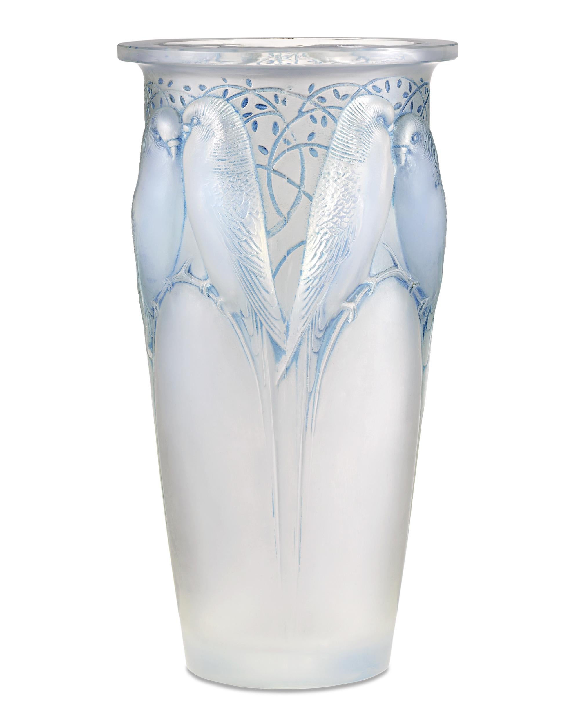 Diese bezaubernde Ceylan-Vase wurde von dem berühmten französischen Glasmacher René Lalique aus opalisierendem Glas mit einem blau gefärbten Rad geformt. Das von Lalique am 16. Mai 1924 entworfene Design ist auch unter dem Namen Huit perruches
