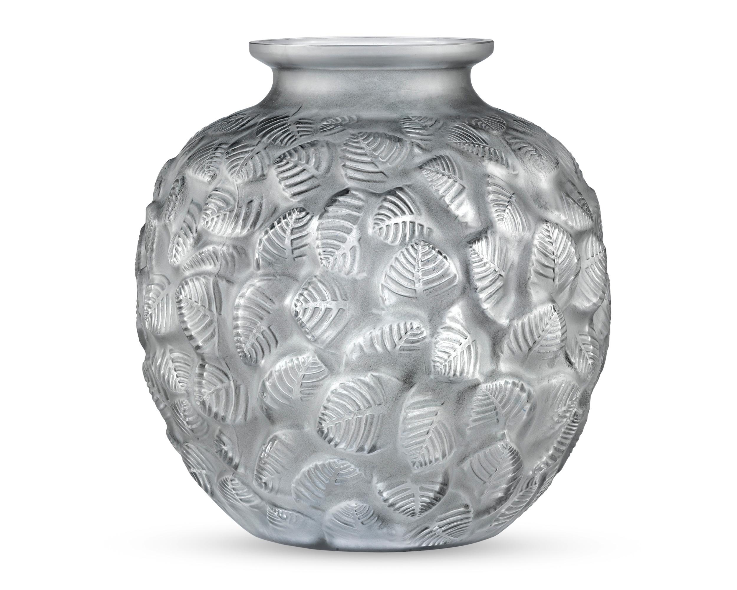 Abstracted foliate motifs swirl atop each other to form this Lalique vase in the Charmilles motif, first designed by René Lalique on October 8, 1926. Inspired by bowers under greenery and composed of elegant frosted glass, this vase embodies the