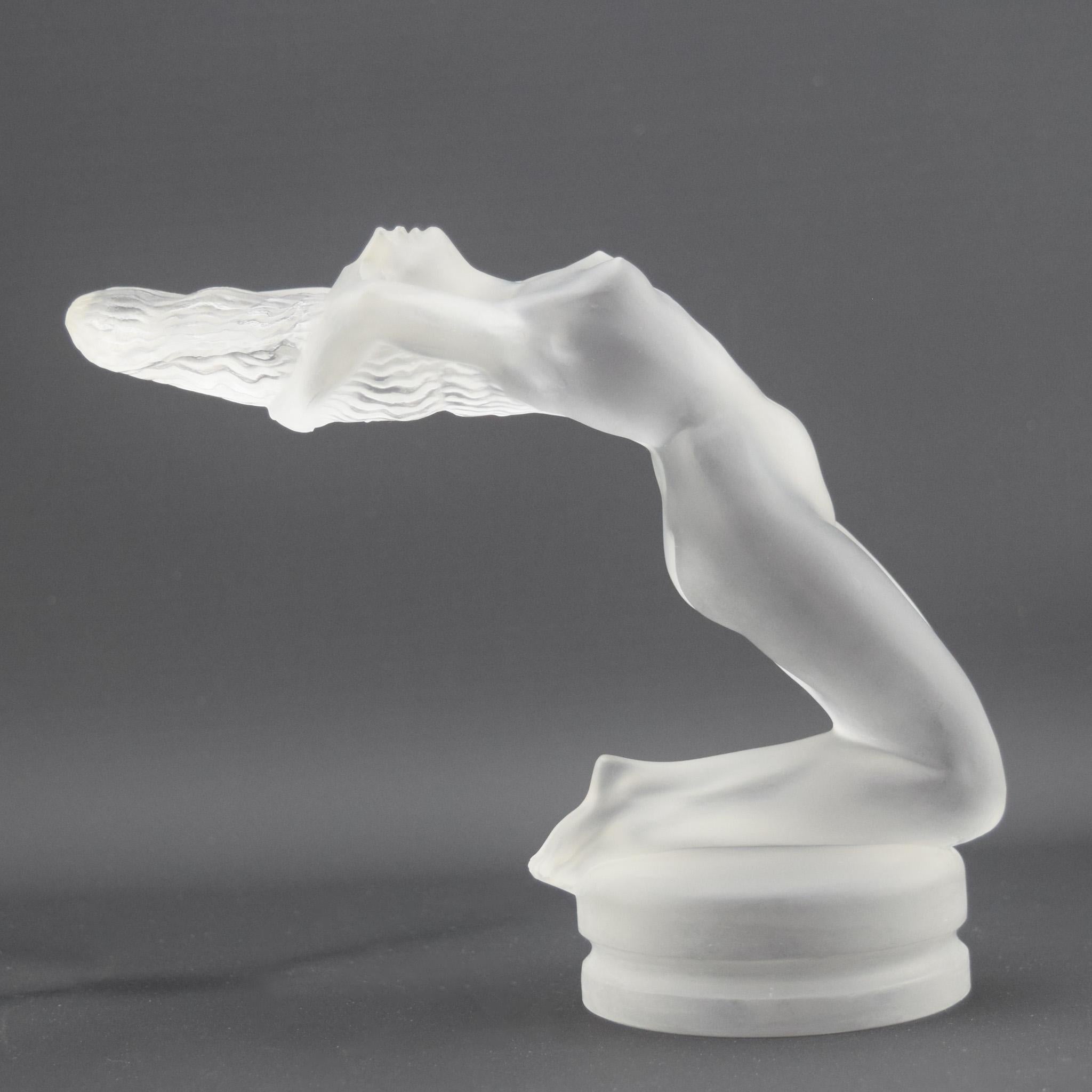 Mascotte per auto di Rene Lalique Chrysis
Modellata come una donna nuda che si appoggia sulle ginocchia con le caviglie incrociate e che tiene i capelli scompigliati dal vento. 

Marcilhac riferimento pagina 505
Modello n. 1183
introdotto nel