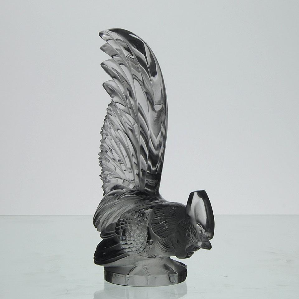 An excellent clear and frosted glass car mascot modeled as a feeding cockerel with fine hand finished detail, especially to the feathering. Signed R Lalique, France.
 
Coq Nain
Catalogue number: 1135
Signature identification: “R. Lalique France”