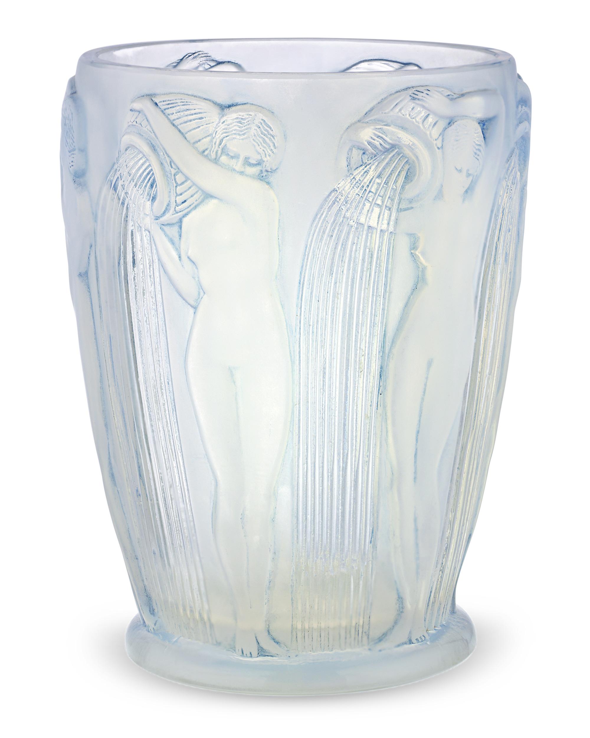 Realizzato dal celebre vetraio francese René Lalique, questo squisito vaso Danaides è uno degli oggetti più belli e unici del maestro artigiano. Realizzato in vetro opalescente lucido con macchie blu, il disegno raffigura bellissime donne nude in