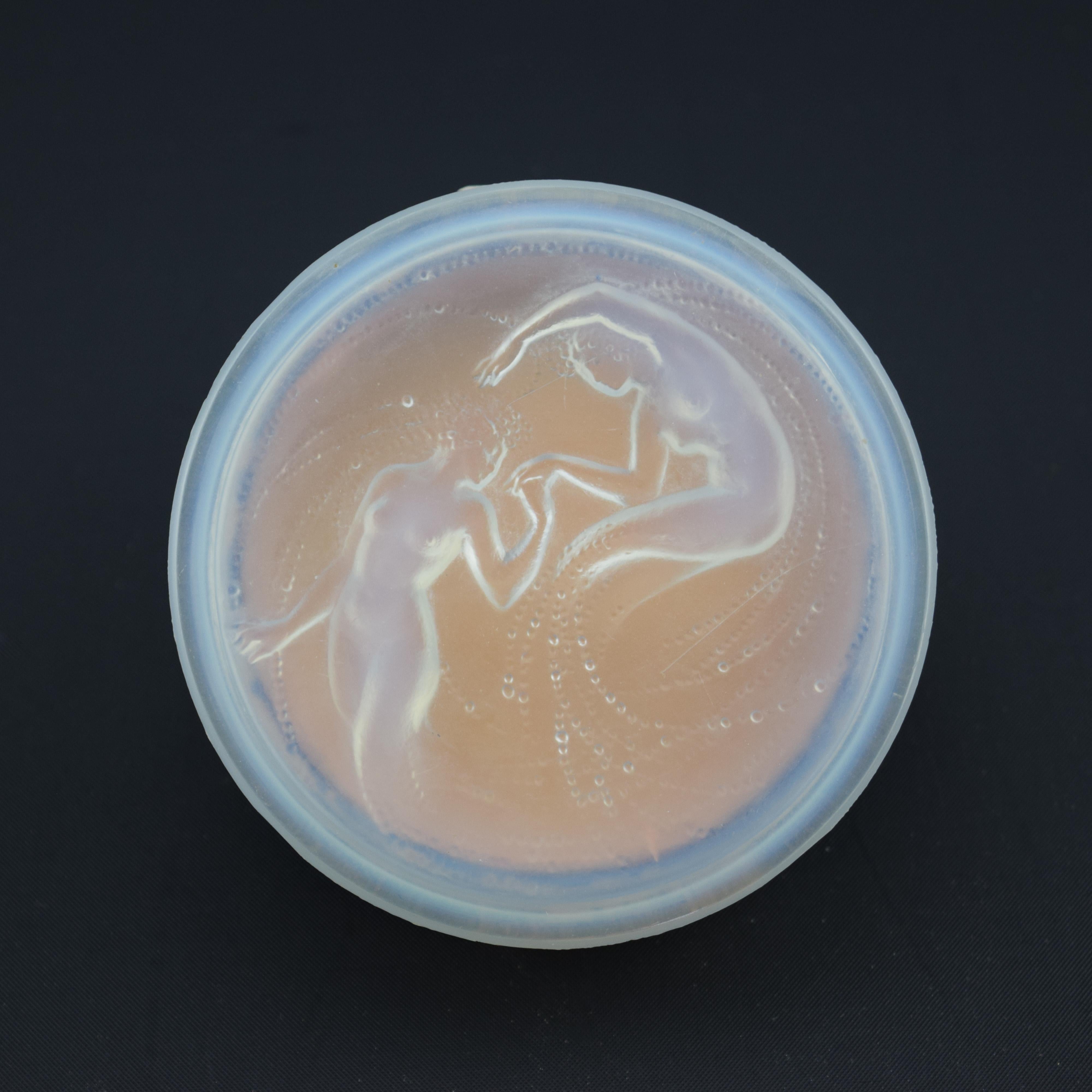 Polvera y tapa Deux Sirenes de René Lalique realizadas para D'orsay. Tiene la base de cartón original y la base de cartón interior que habría contenido el polvo. Esto se ve raramente, ya que normalmente se descartan.
La tapa deux Sirenes tiene una