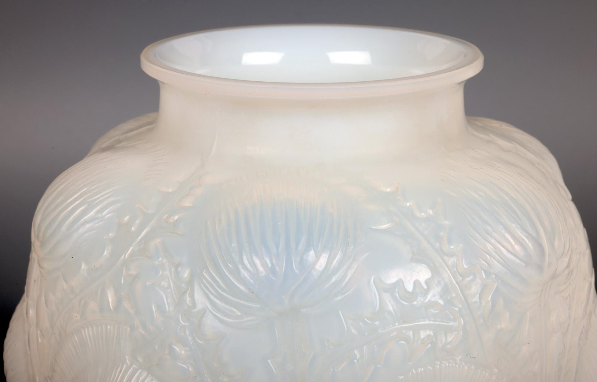 Un superbe vase Domrémy (créé en 1926) en verre opalescent de René Lalique (français, 1860-1945) datant d'environ 1926. Le vase repose sur un étroit pied rond et plat poli, avec une base en retrait, et est décoré de chardons moulés sur des tiges