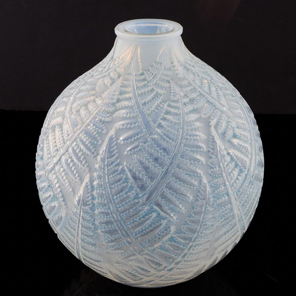 A Rene Lalique 'Espalion' or 'Fougères' Vase designed in 1927. The bowl features
patinated in pale blue glass with interlocking fern fronds on an opaque background. It is acid stencil marked R Lalique to the base. 

Both names are given in