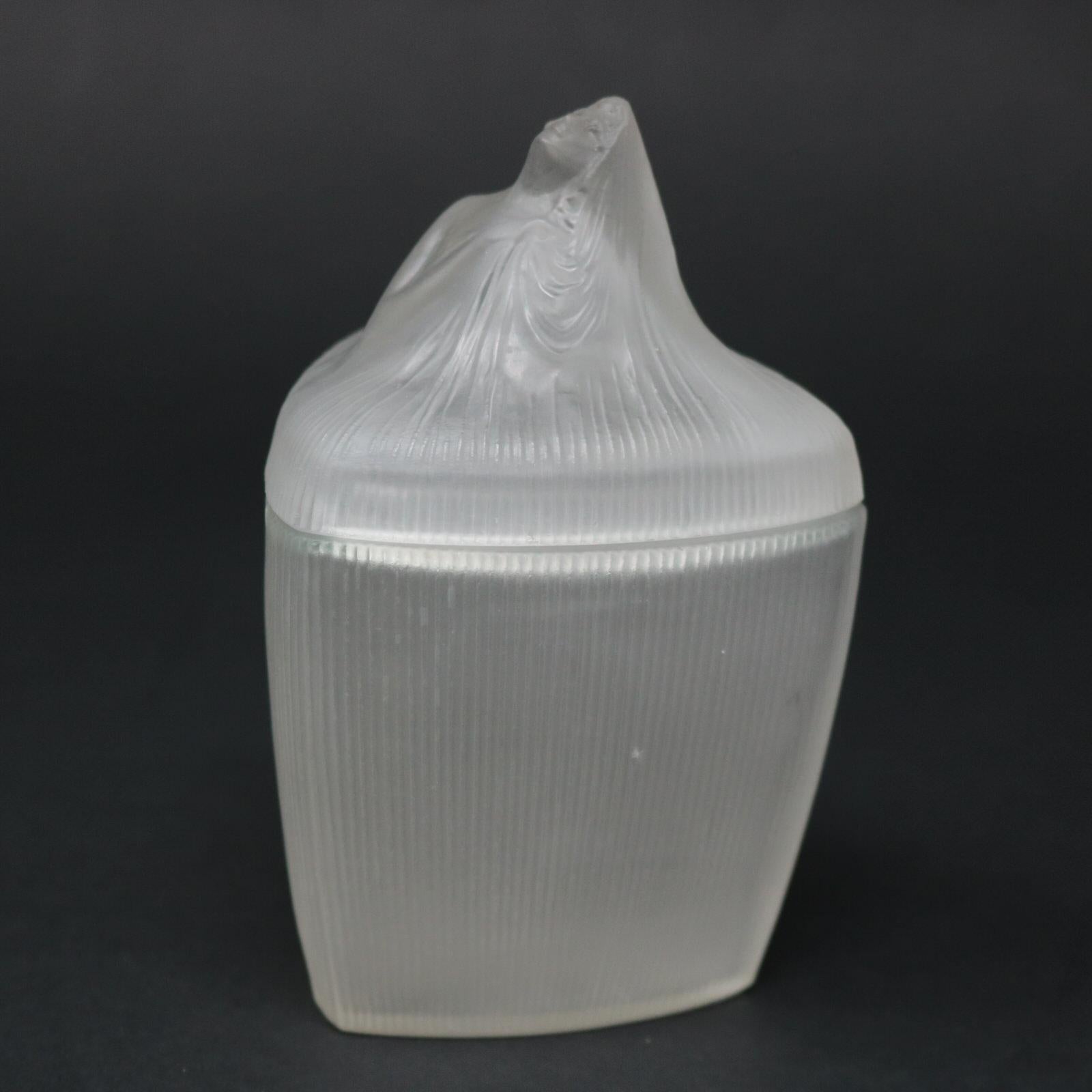 Rene Lalique frosted glass Coty-4 'Tete Femme' triangular ointment jar. This model features a female head on the lid, wearing a long veil. The veil flows down the lid, forming the decoration for the sides of the pot. Moulded makers mark, 'R