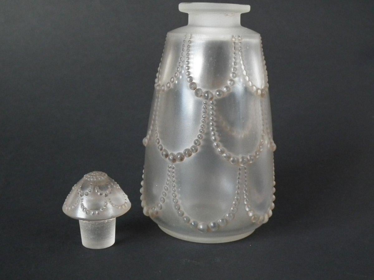 René Lalique clear and frosted glass, 'Perles No.3' perfume bottle. Traces of original grey stained details. Pattern features strings of pearls. Moulded makers mark, 'R Lalique'. Book reference: Marcilhac 602.
 